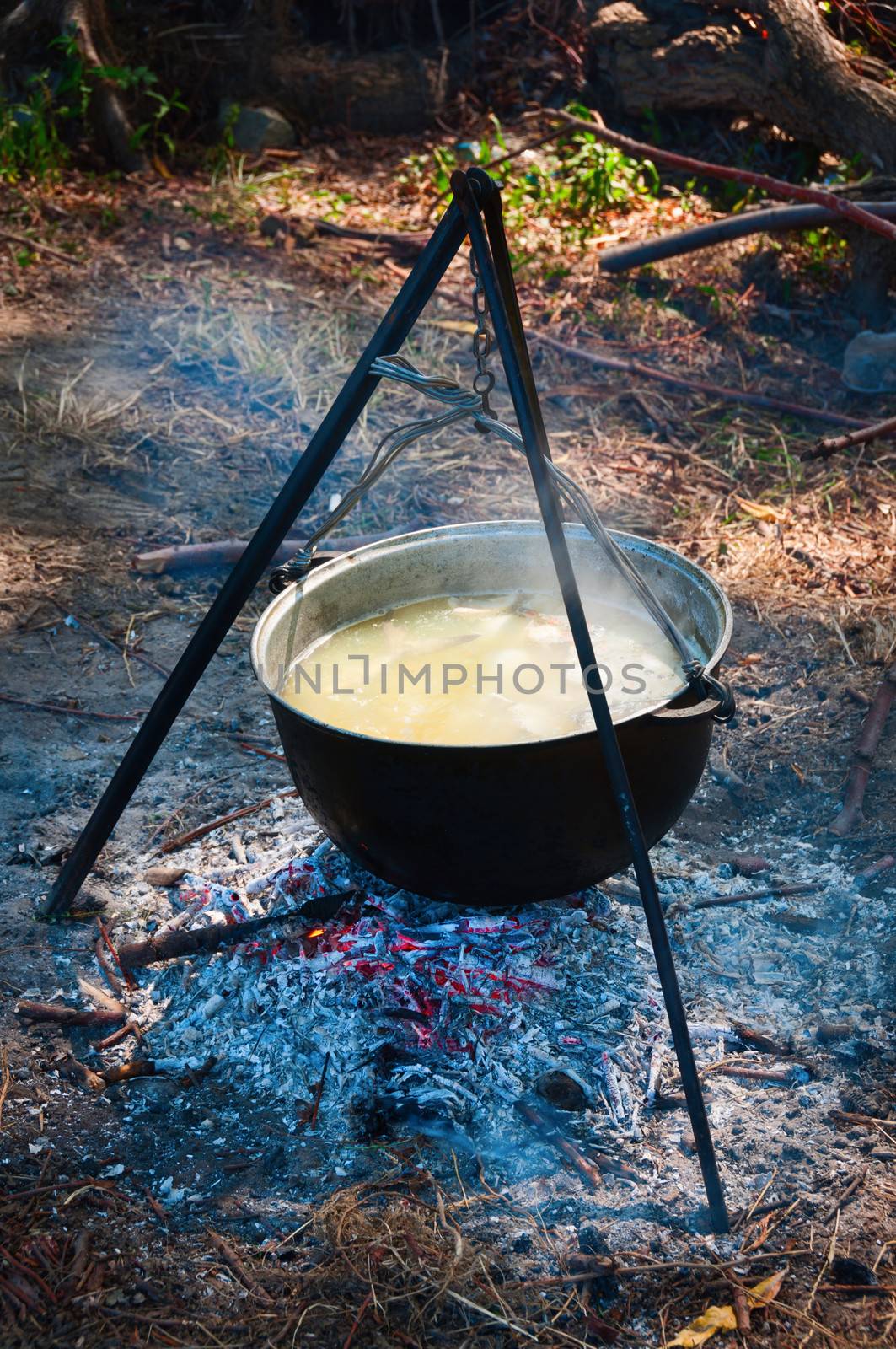 Tourist kettle above a fire with fish soup 
