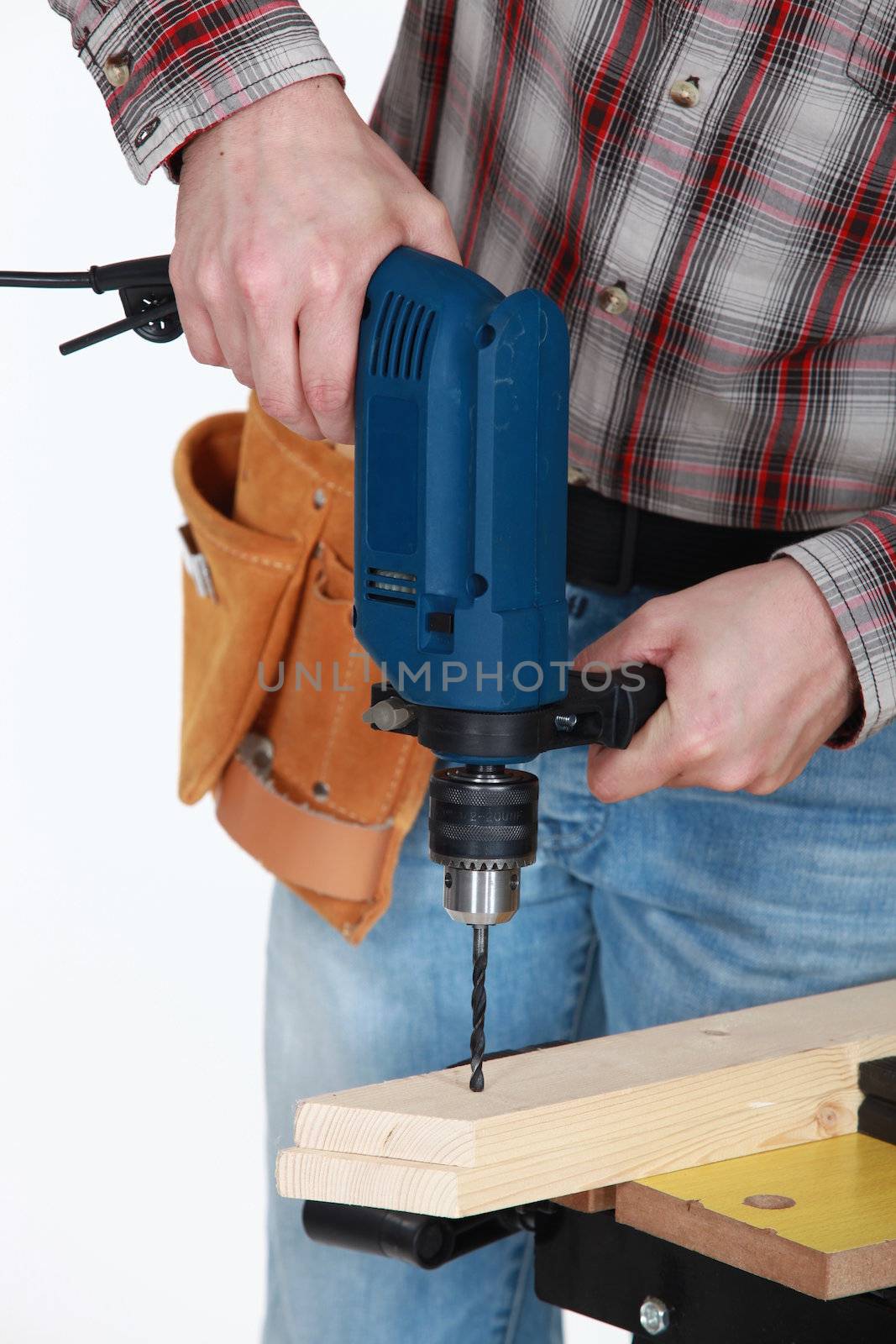 Man drilling through plank of wood