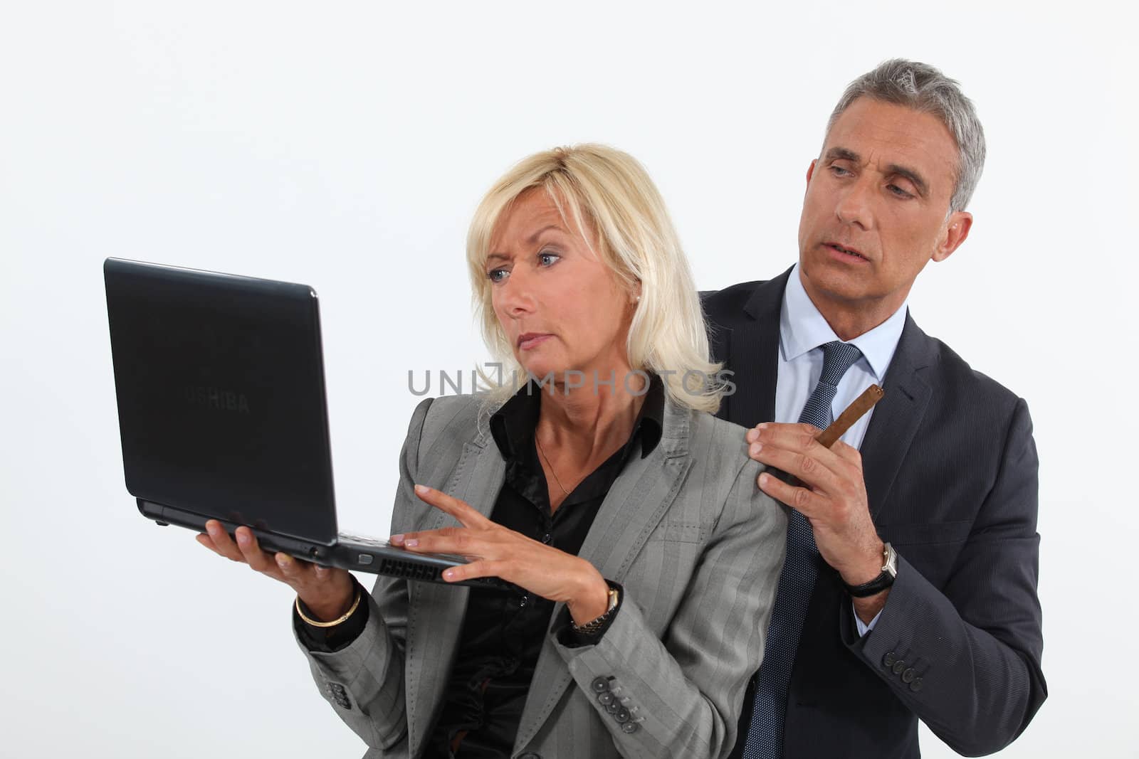 businessman and businesswoman analyzing information on their laptop by phovoir