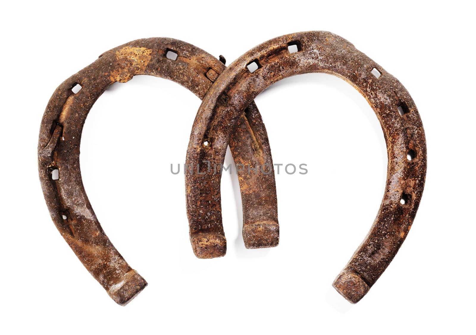 Old rusty and worn horseshoes isolated on white with natural shadows.