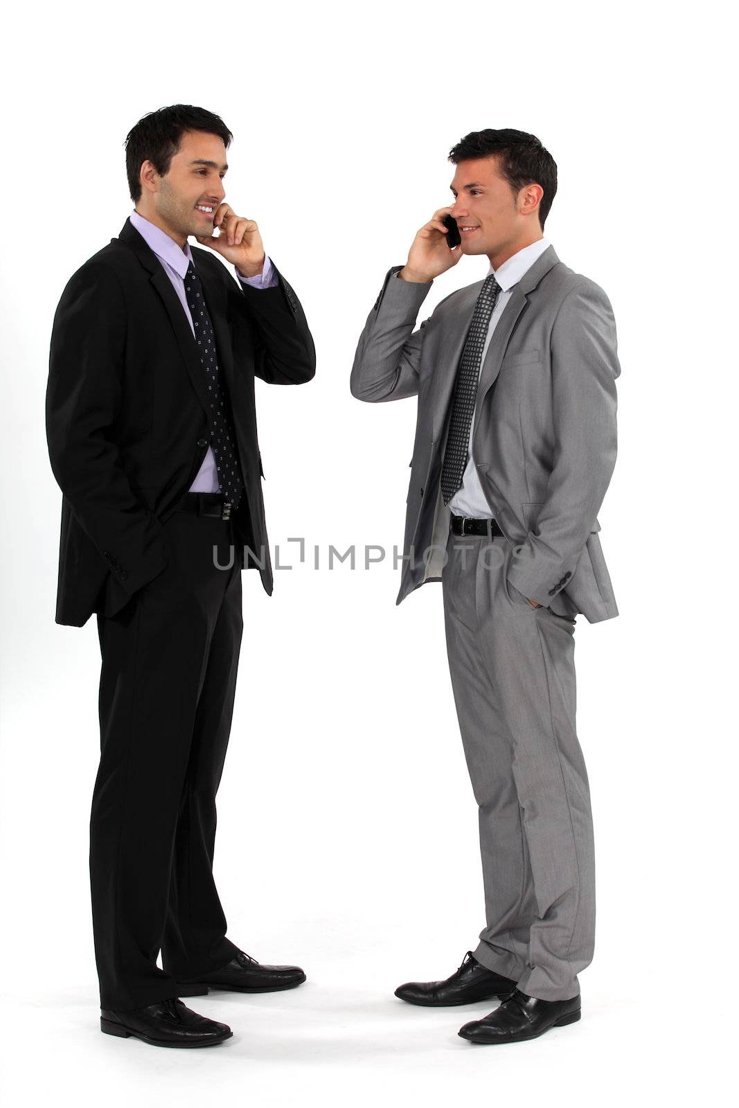 Young businessmen using cellphones by phovoir