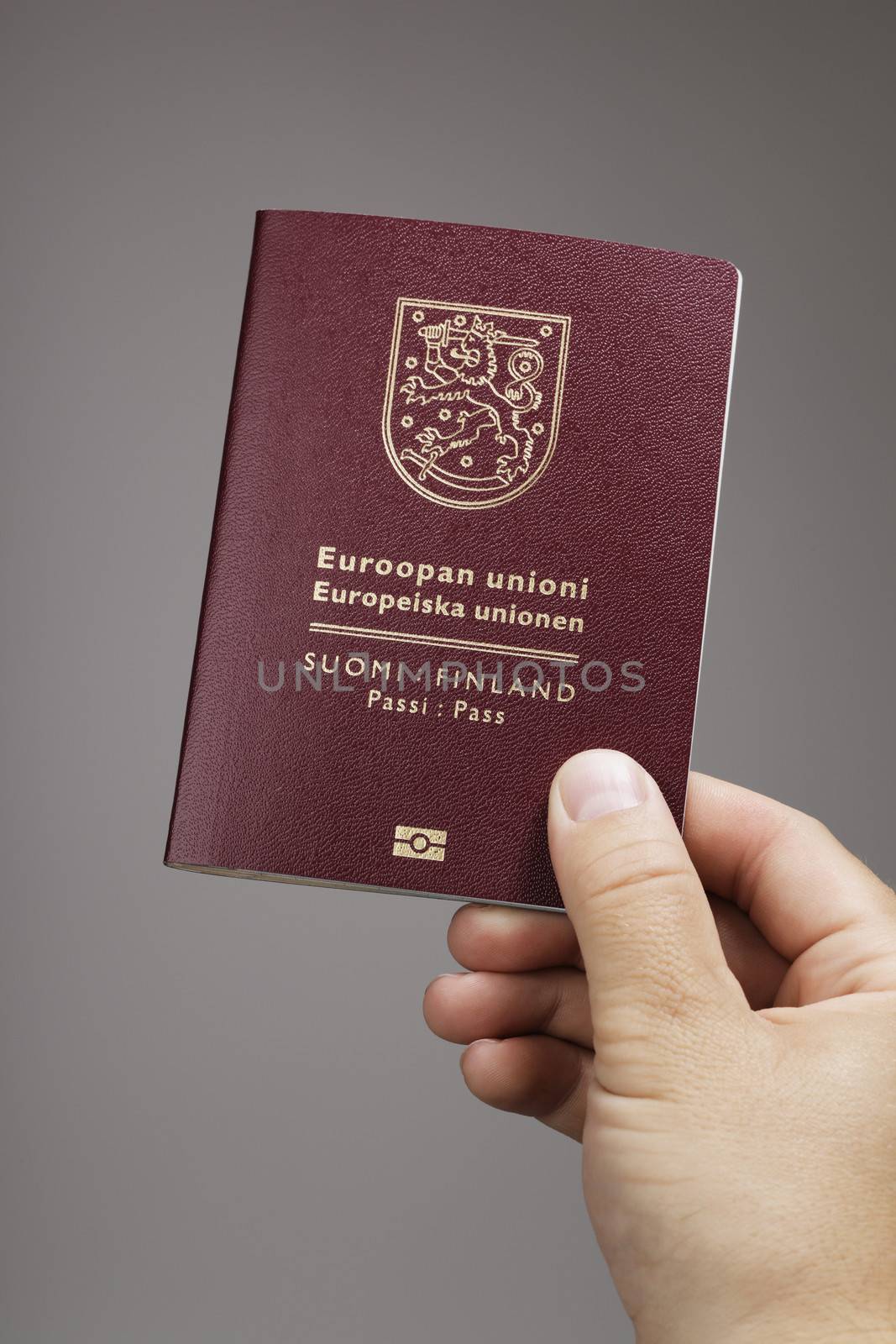 Man holding a Finnish (Finland) passport ih his hand. This is the new (2013) of the passport.