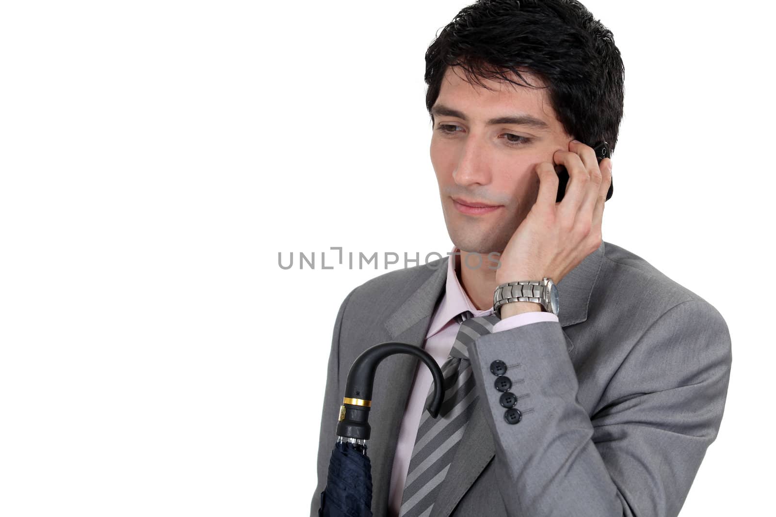 Weary businessman talking on his mobile phone by phovoir