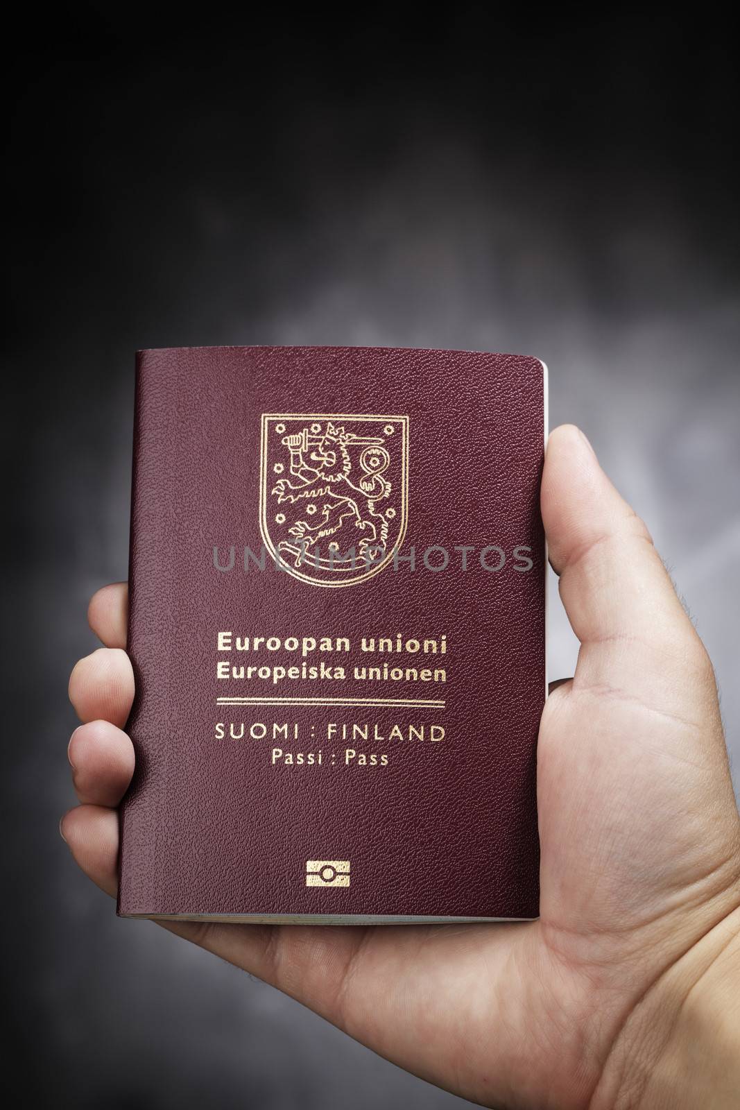 Hand holding a Finnish (Finland) passport. This is the new (2013) design of the passport.