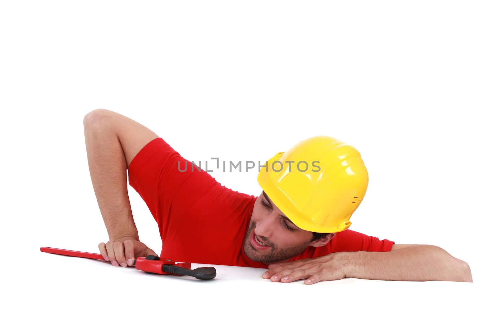 A construction worker looking at his wrench.