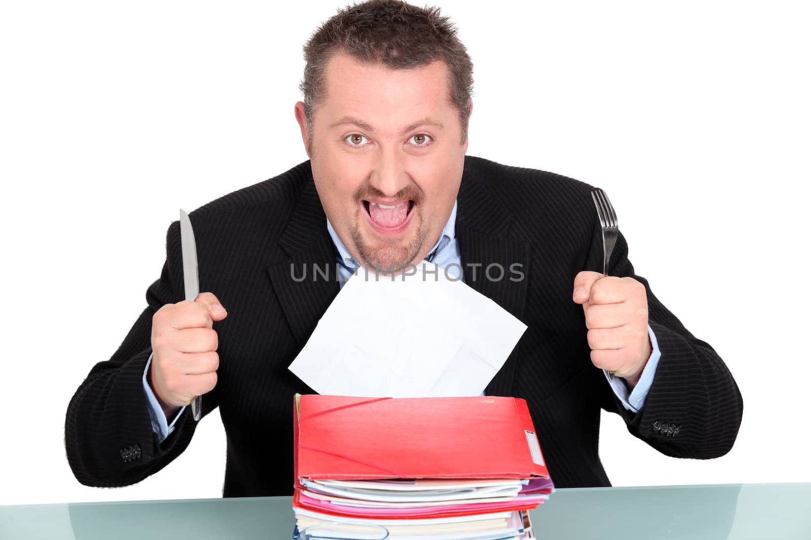 Businessman devouring a pile of paperwork