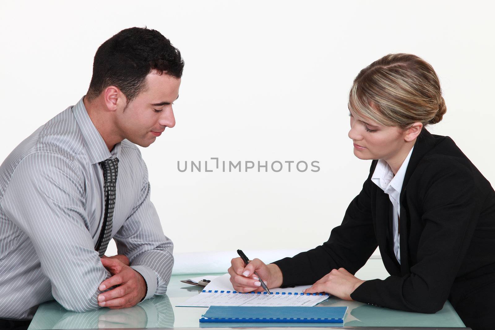 Woman explaining contract to man by phovoir
