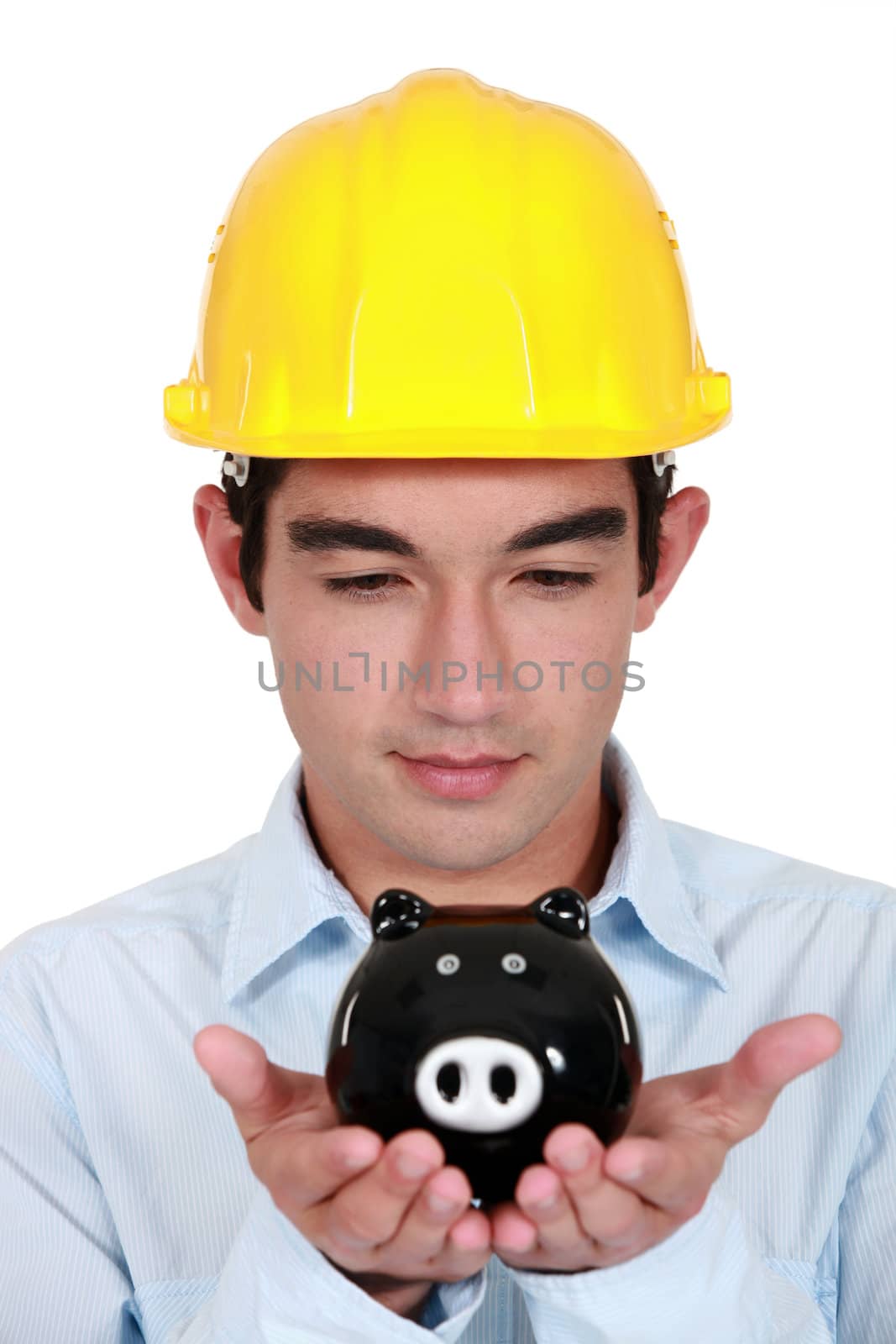 Young construction worker with piggy bank in hands