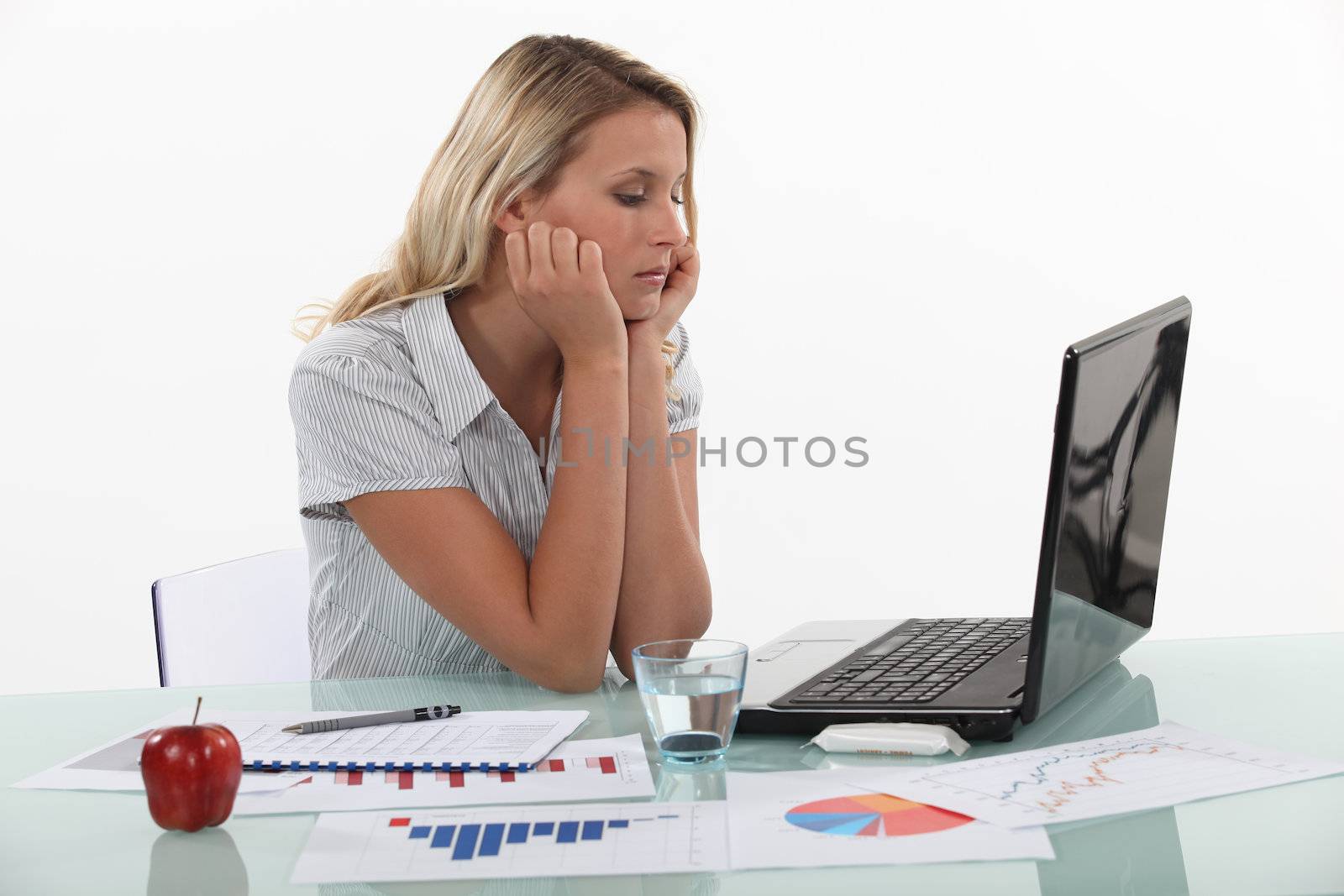 Young woman pensive in front of laptop computer