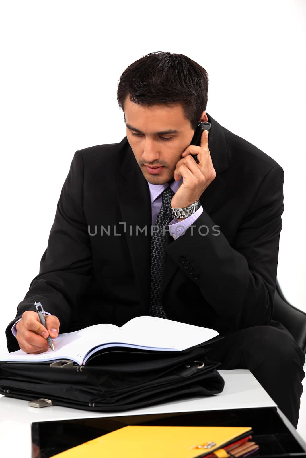 Businessman taking notes during important call