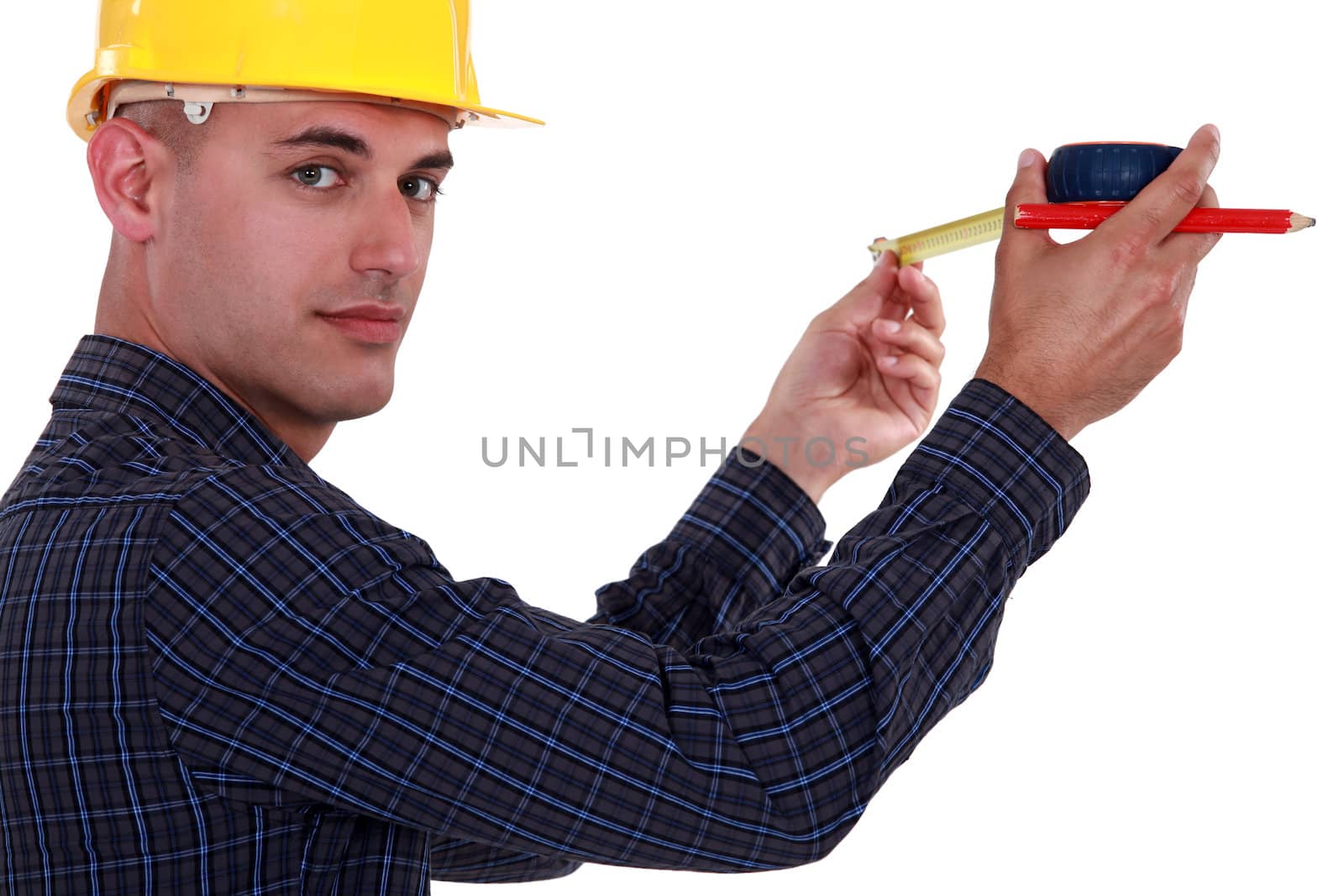 Tradesman using a measuring tape by phovoir