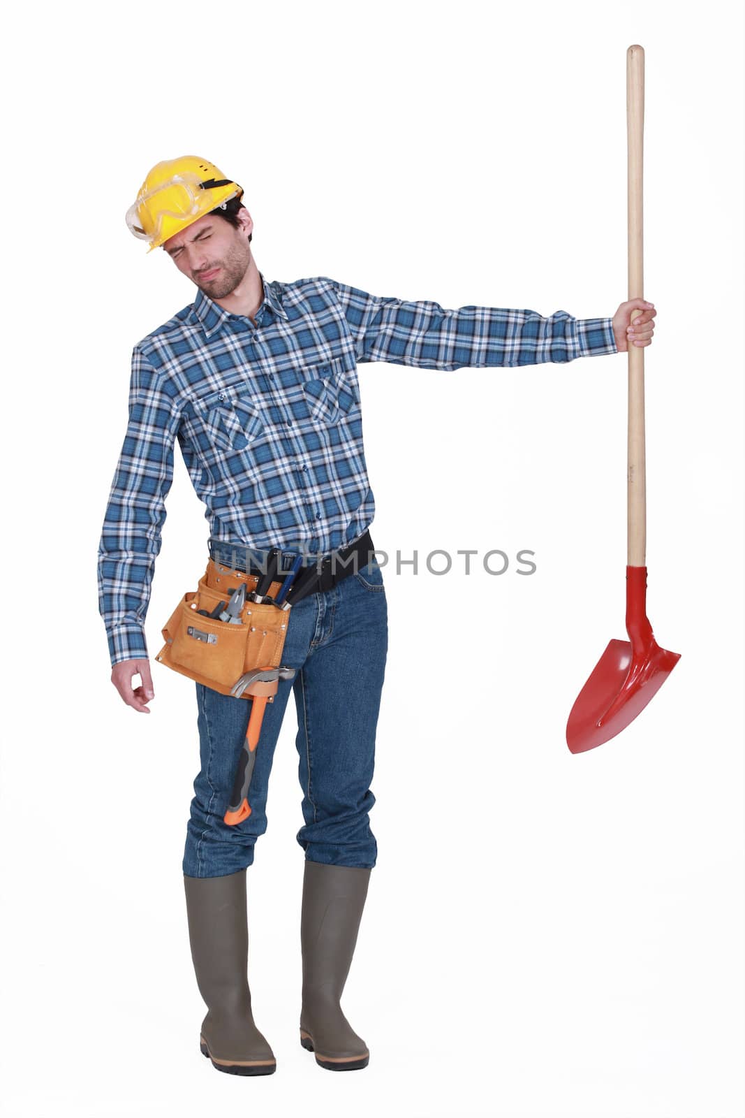 Disgusted man holding shovel by phovoir