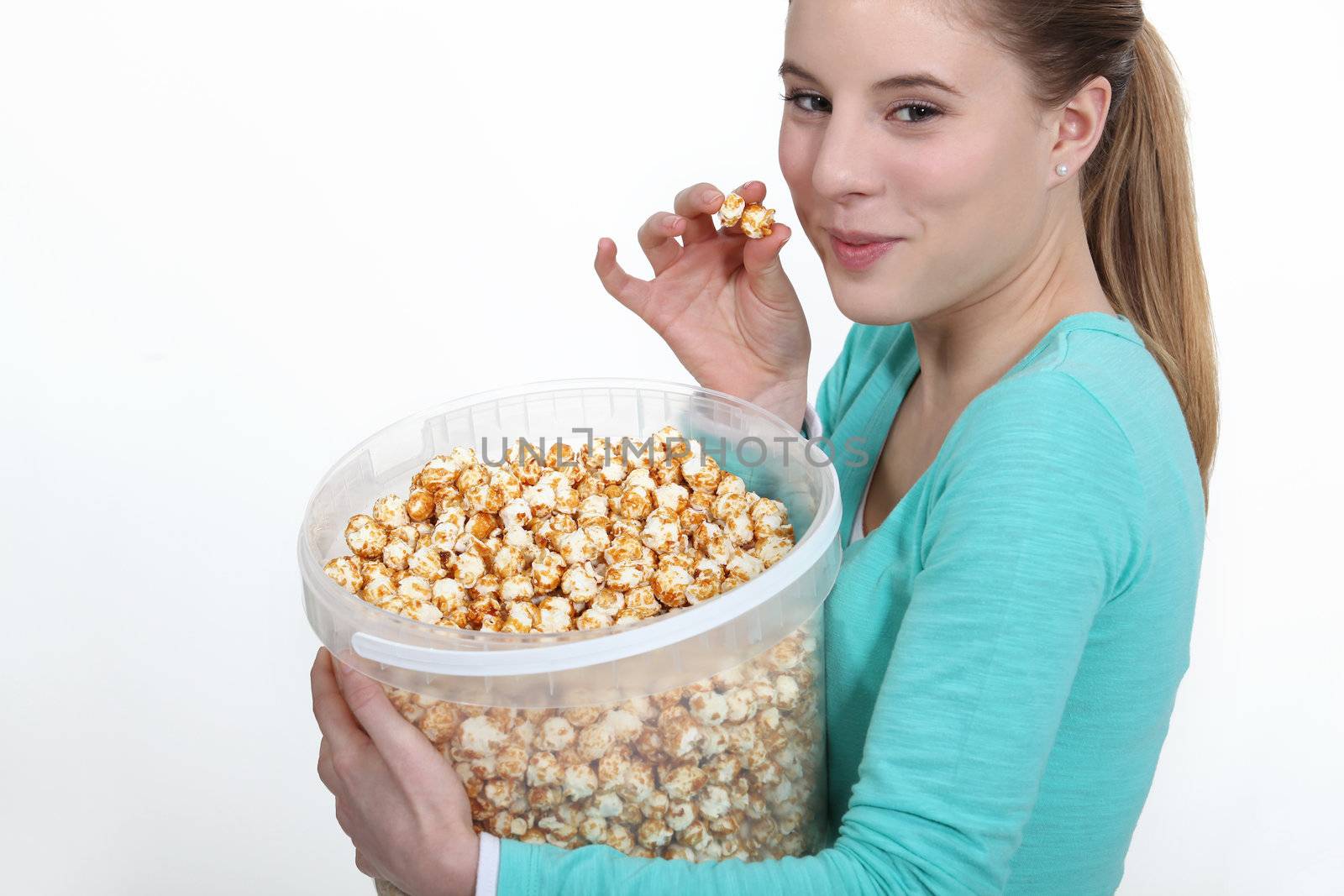 Woman eating popcorn from large bucket by phovoir