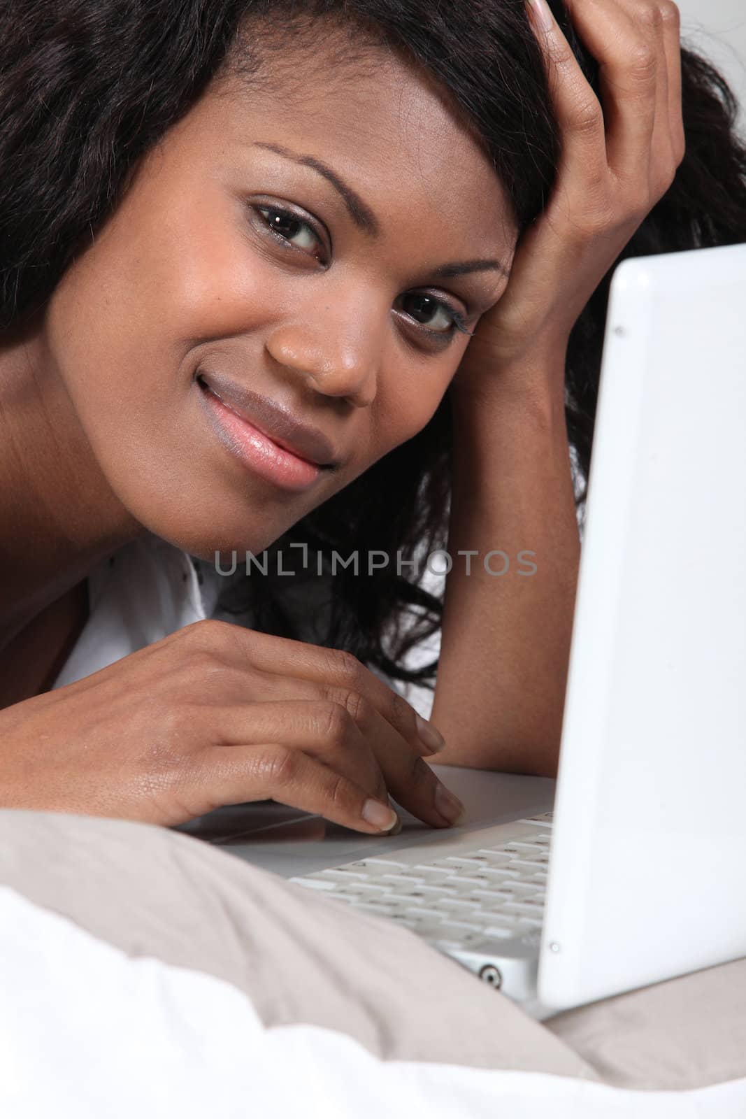 Woman in bed using laptop
