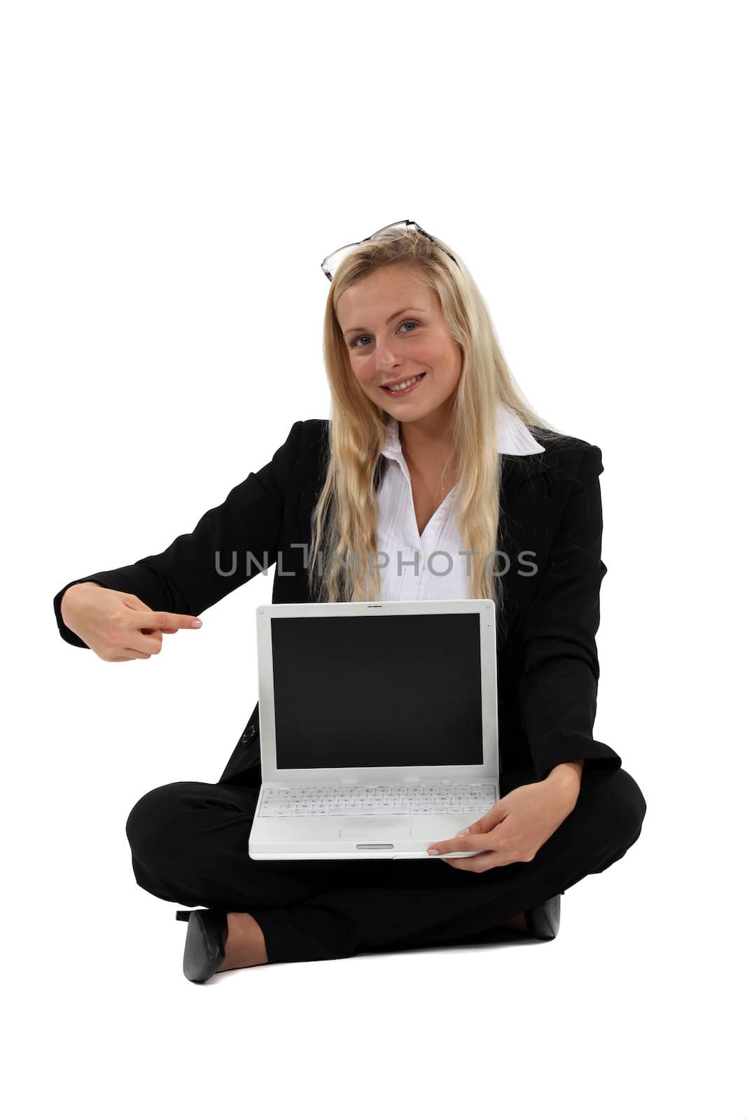 Blond businesswoman sat pointing at laptop by phovoir