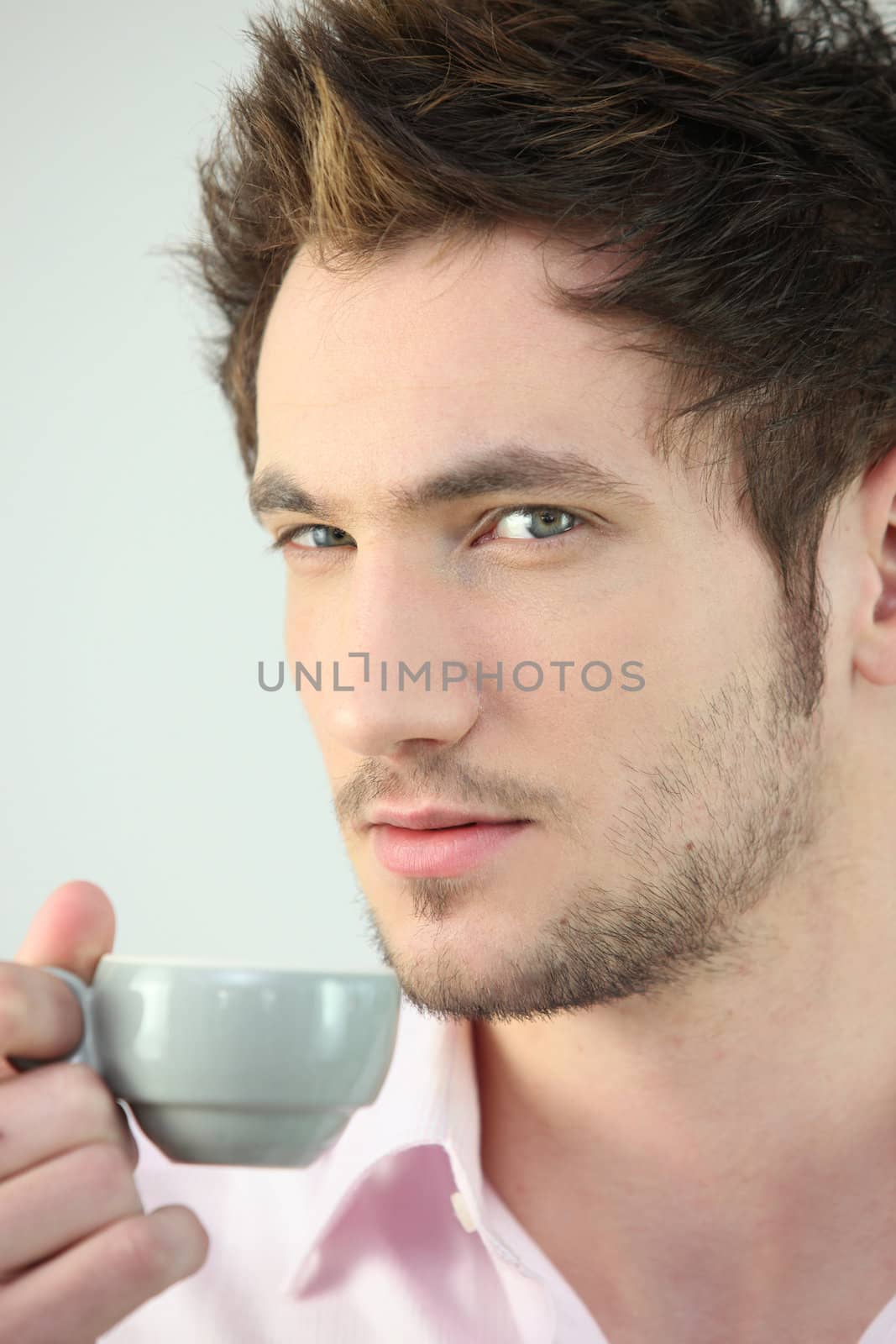 Man holding cup of coffee by phovoir