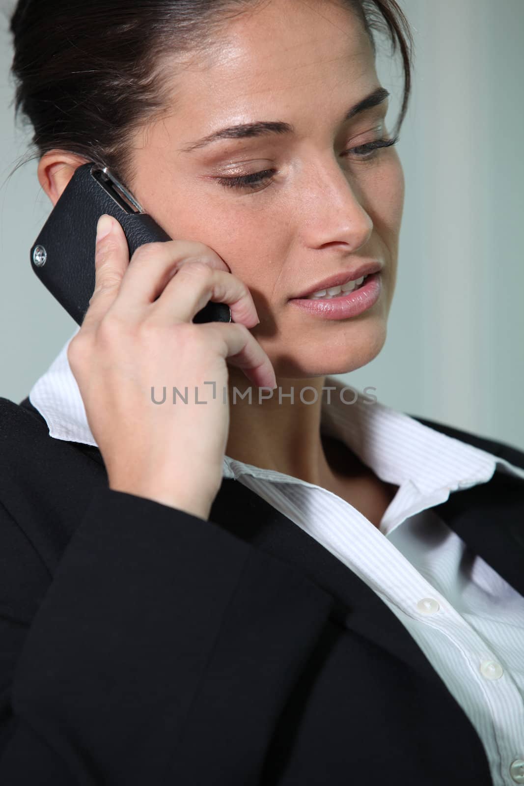 Businesswoman smiling holding mobile telephone by phovoir