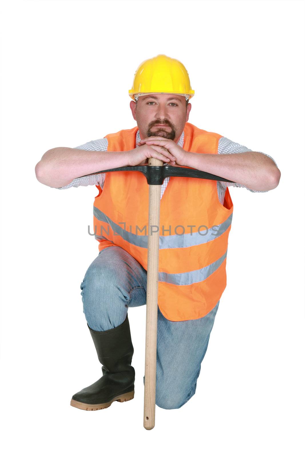 Construction worker leaning on a pickaxe by phovoir