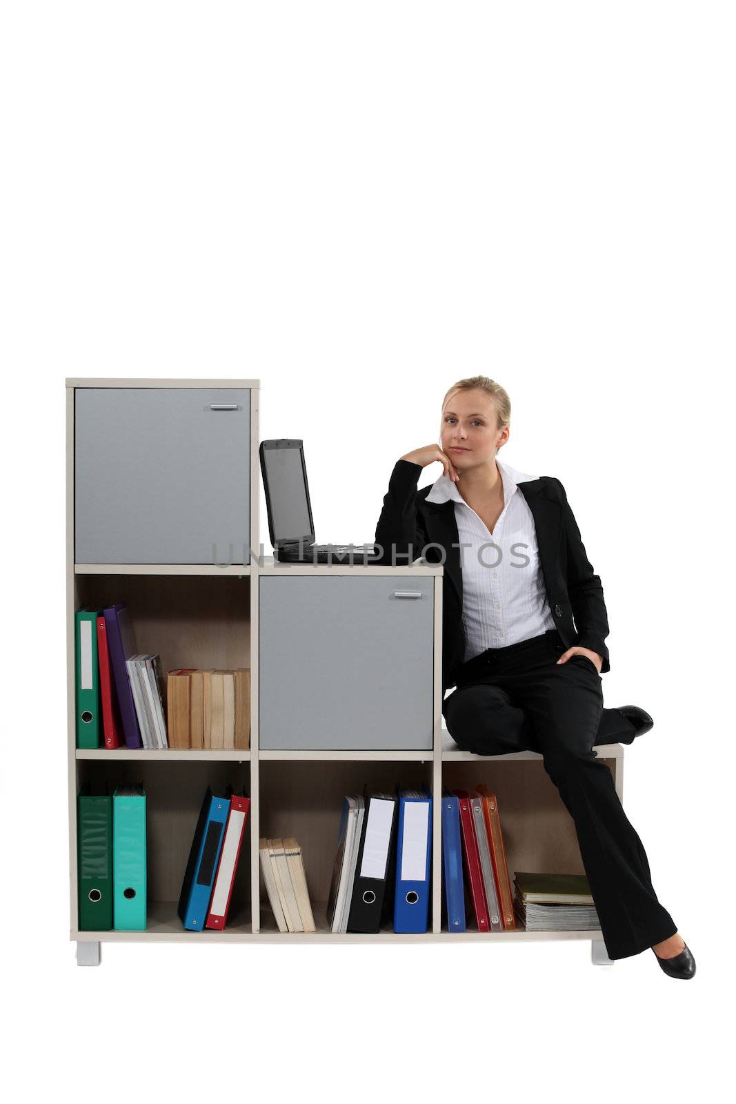 Woman sitting by modern bookcase