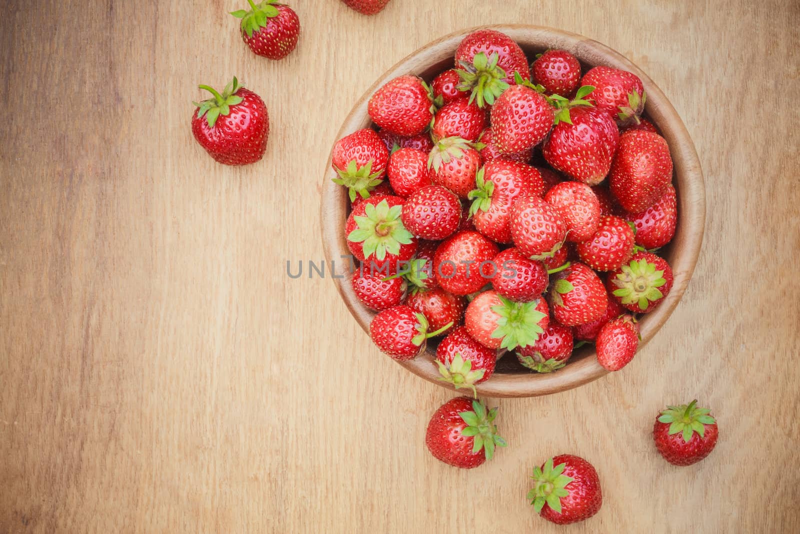 Old Wooden Bowl Filled With Succulent Juicy Fresh Ripe Red Strawberries On An Old Table top