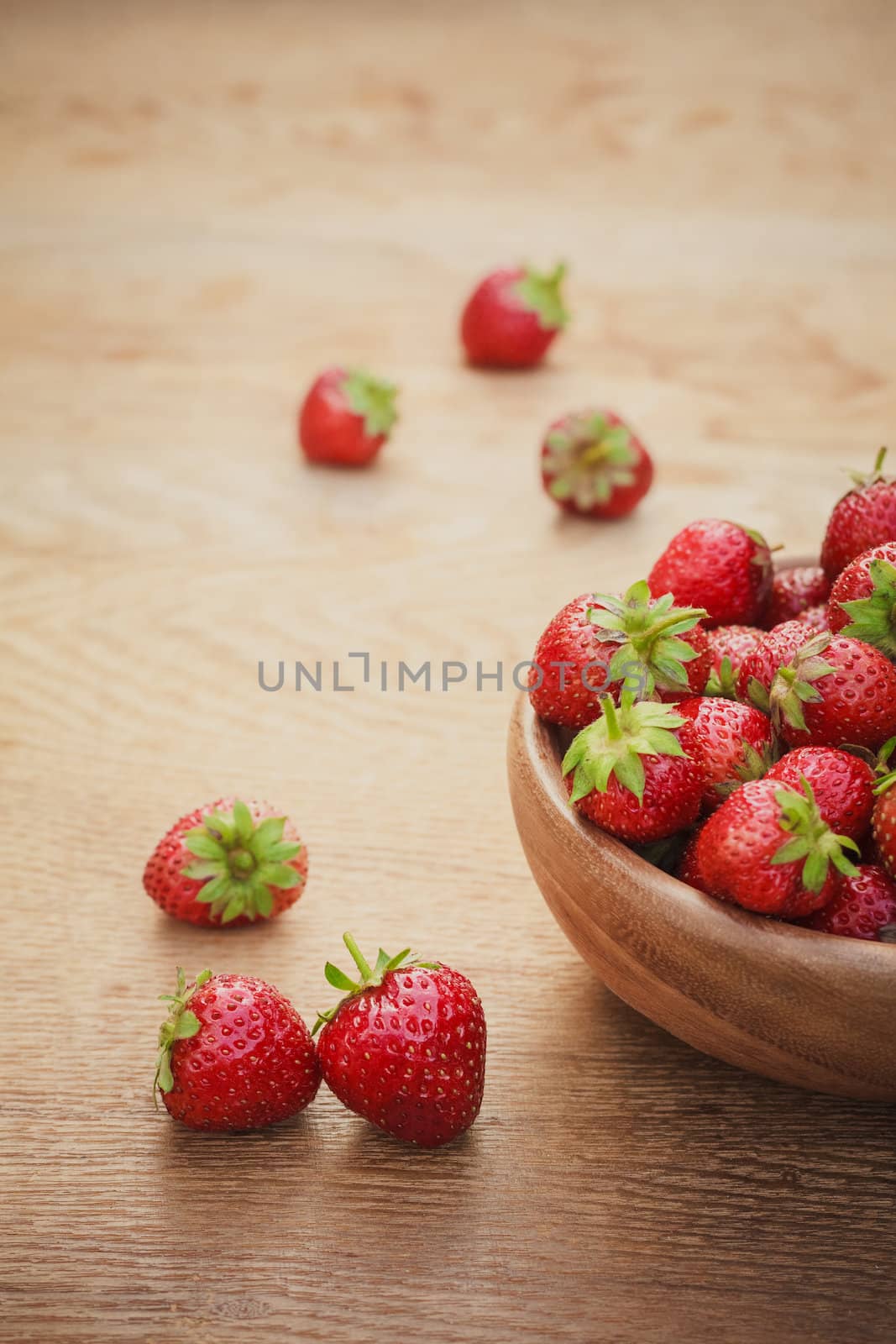 Old Wooden Bowl Filled With Succulent Juicy Fresh Ripe Red Strawberries On An Old Table top