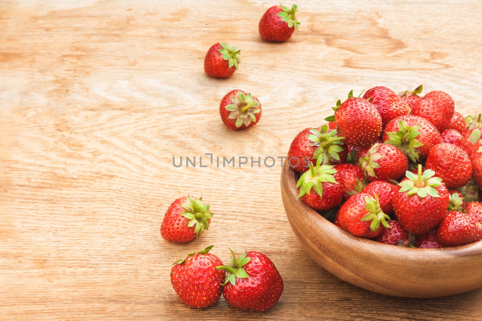 Old Wooden Bowl Filled With Succulent Juicy Fresh Ripe Red Strawberries On An Old Table top