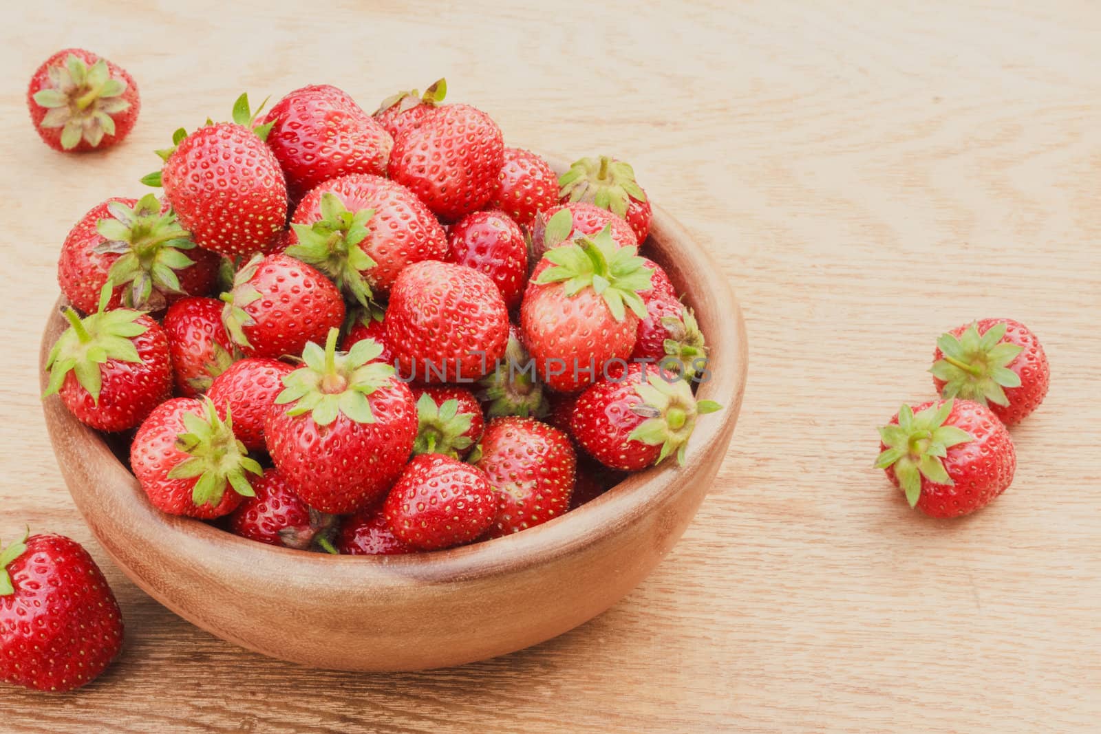 Old Wooden Bowl Filled With Succulent Juicy Fresh Ripe Red Strawberries On An Old Table top