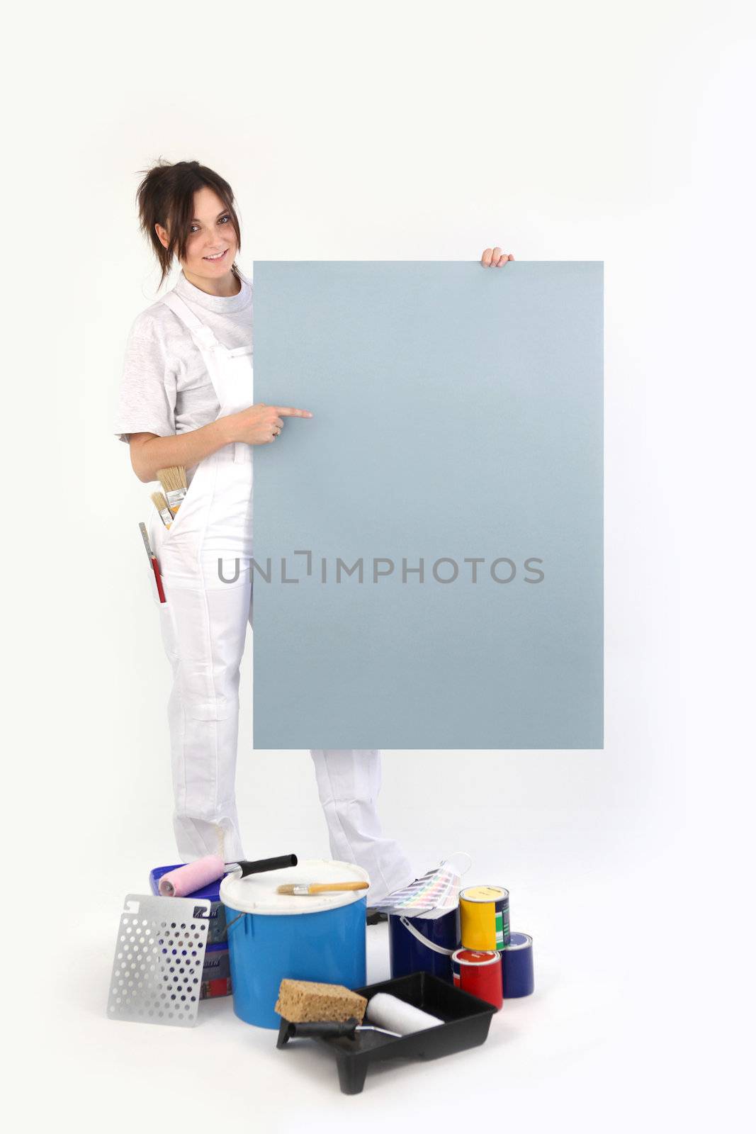 Female decorator pointing to a blank poster