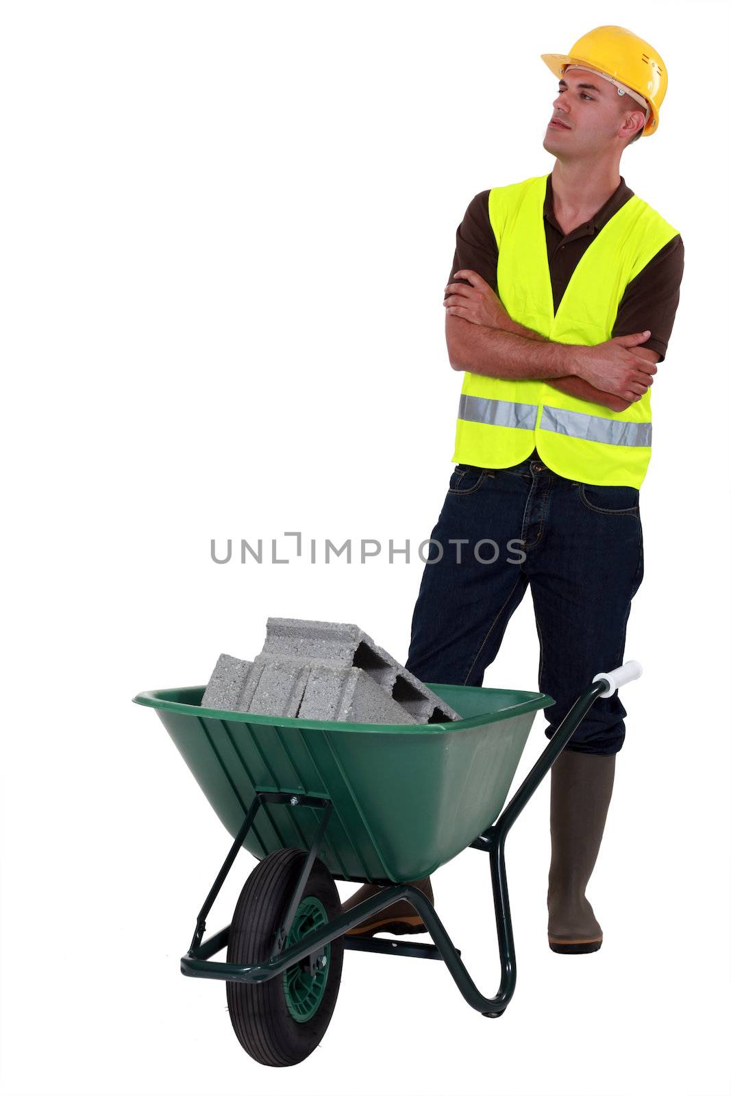 Construction worker with a wheelbarrow by phovoir