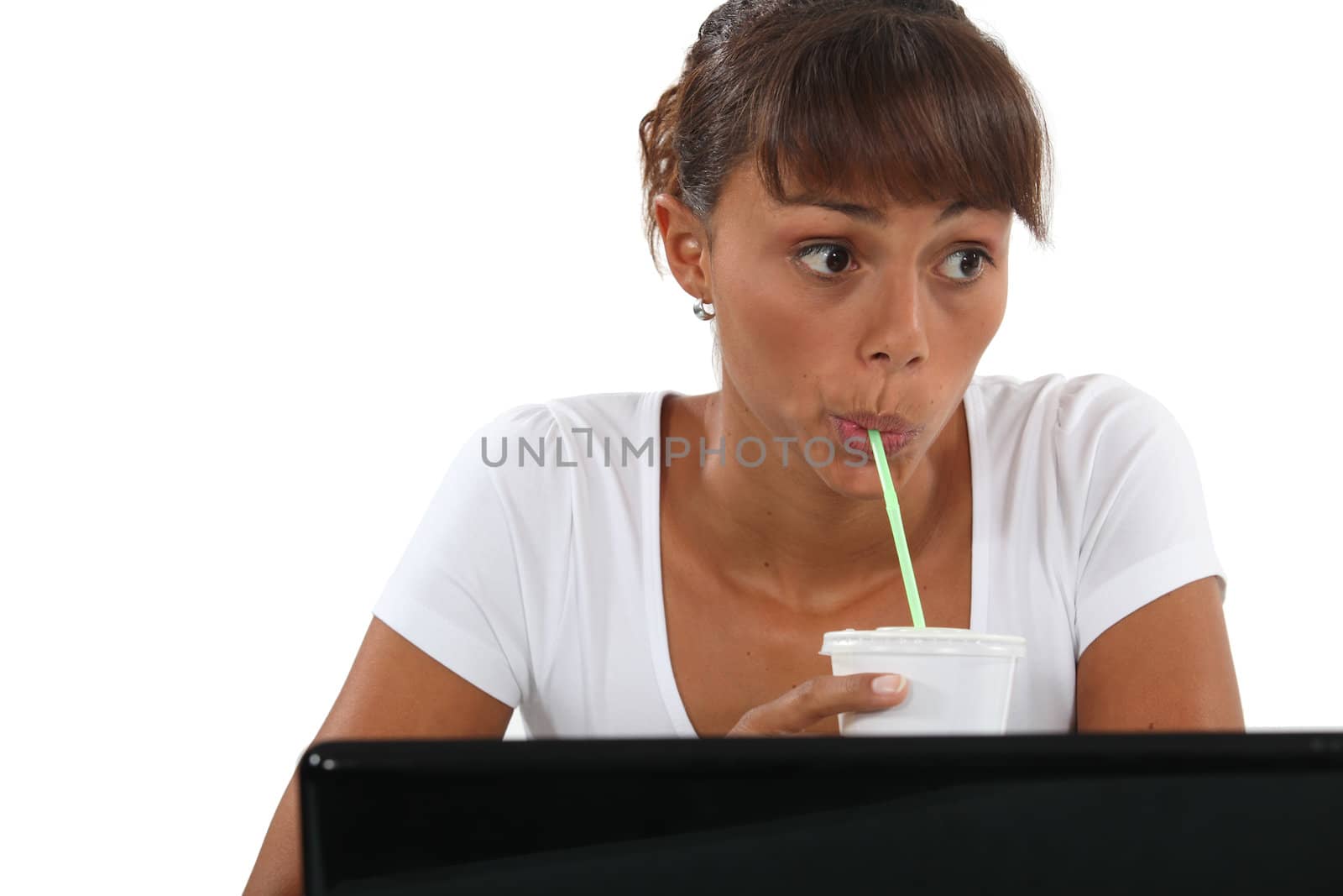 Woman drinking through straw at desk