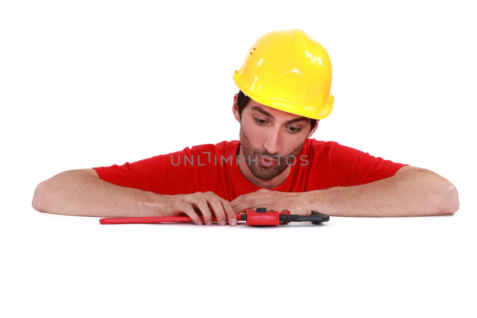 Plumber looking at his tool surprisingly