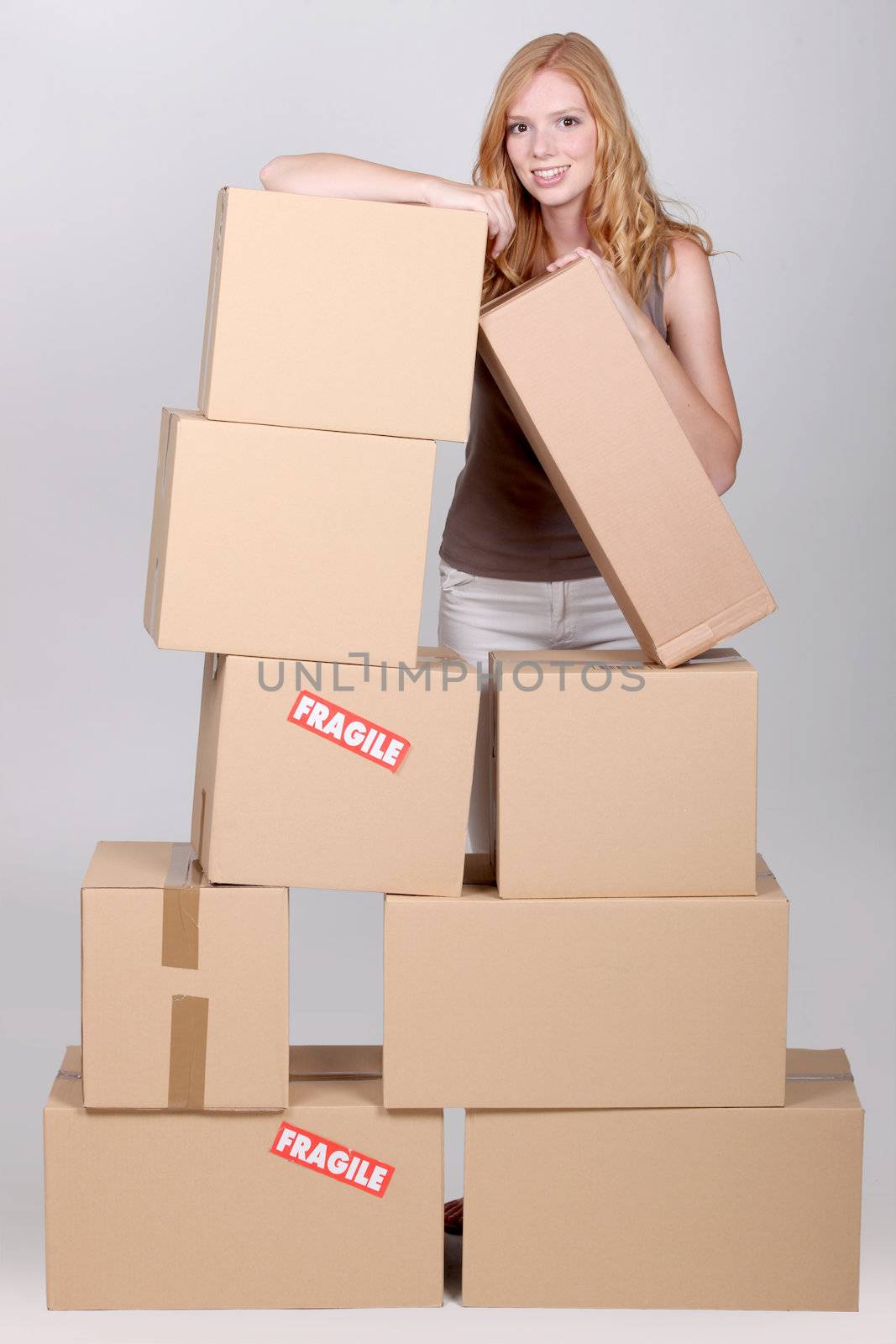 Young woman surrounded by cardboard boxes by phovoir