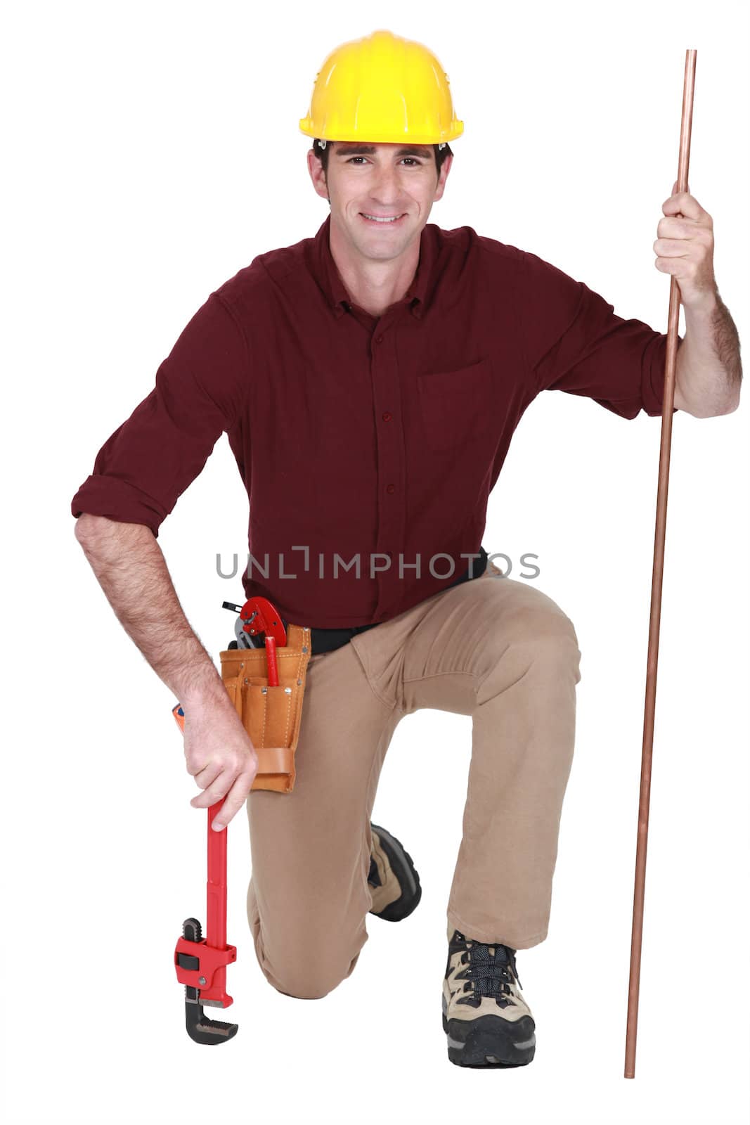 portrait of handsome plumber with adjustable wrench and pipe