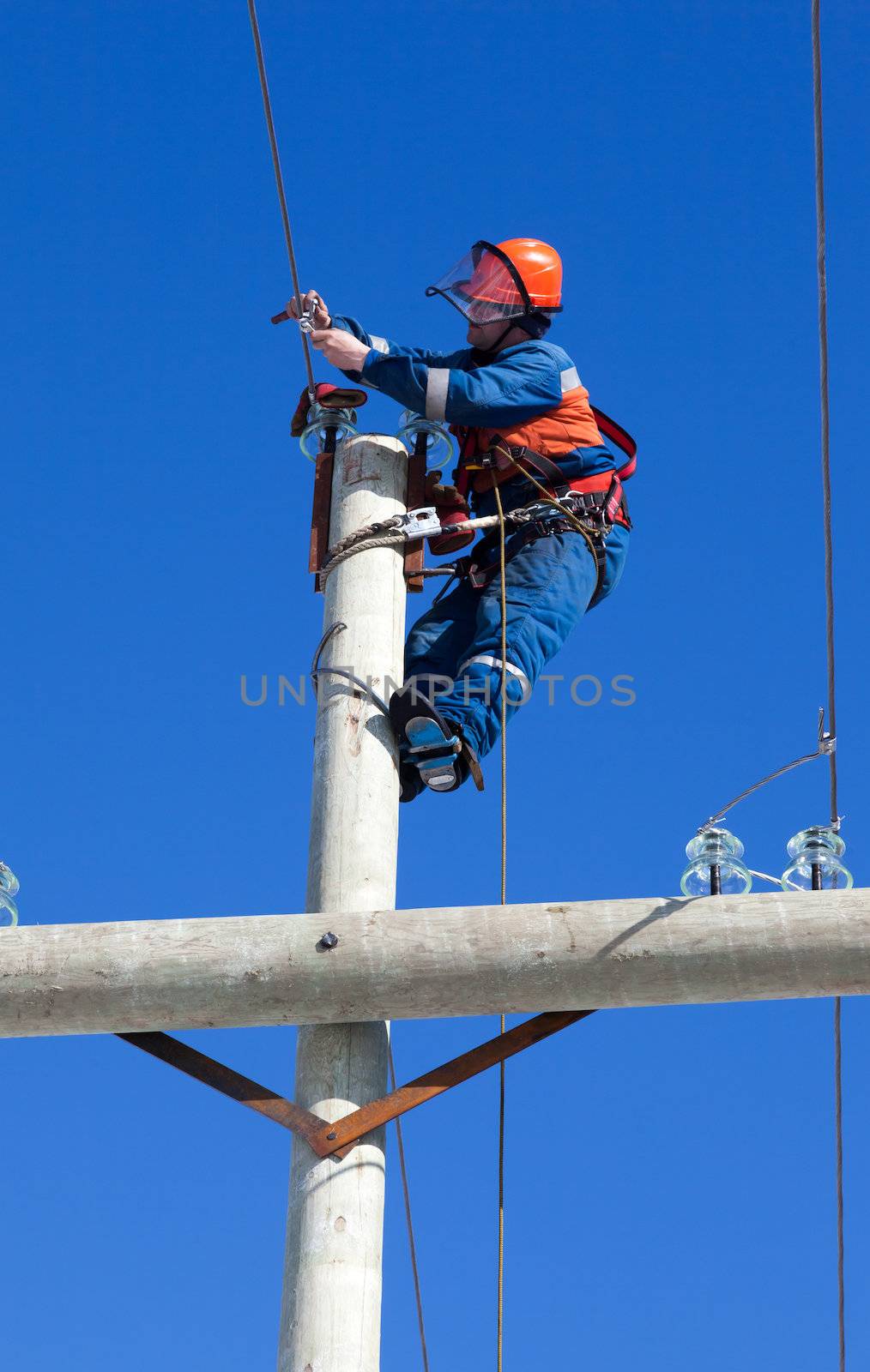 electrician working on top of an electricity pylon by AleksandrN