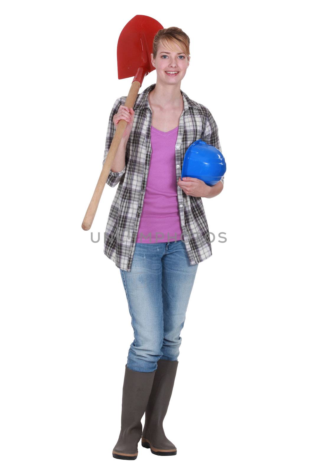 A female construction worker holding a shovel.