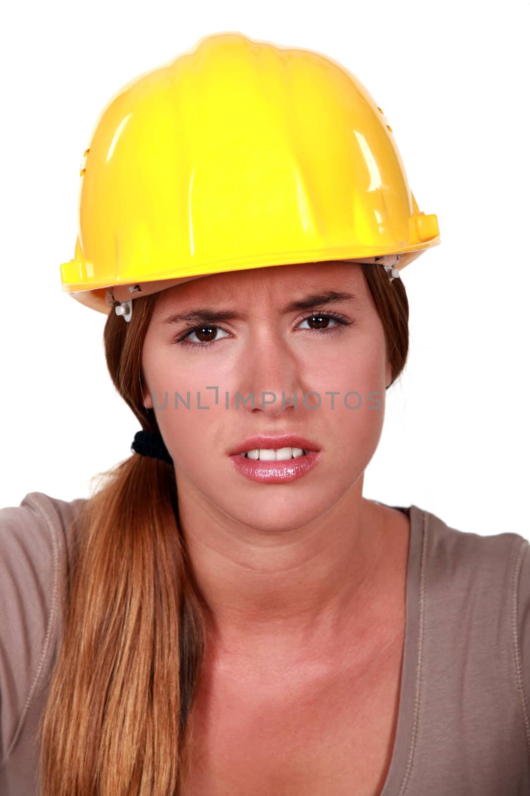 Concerned woman in a hardhat by phovoir