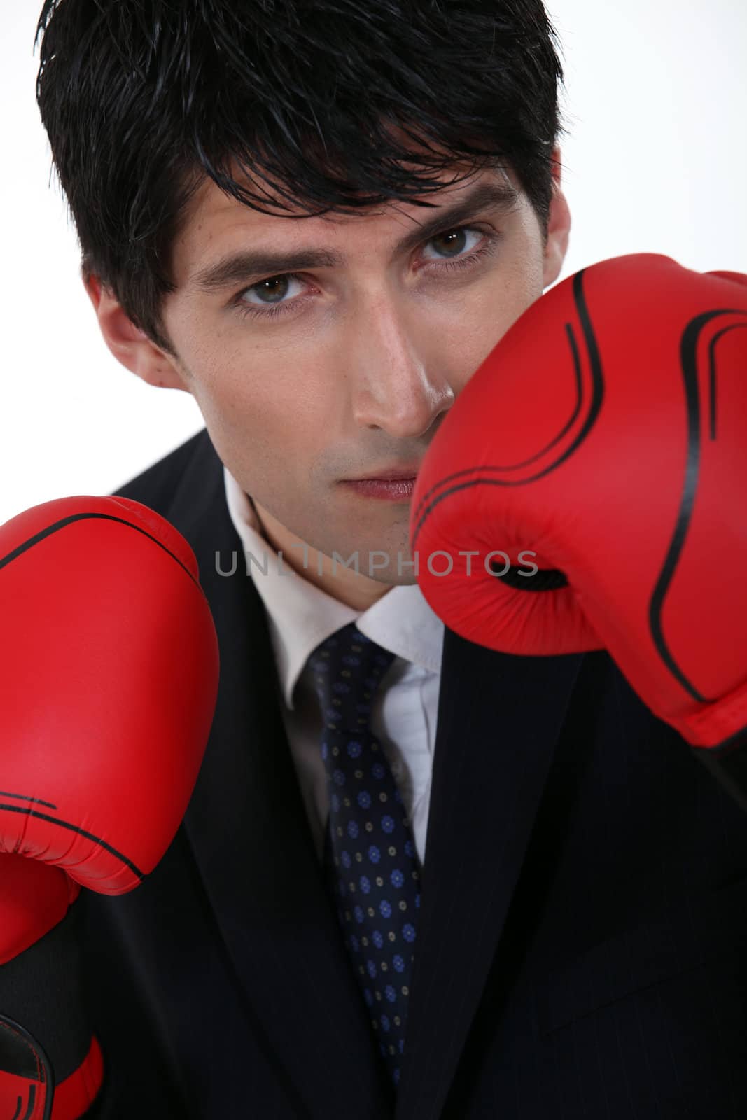 handsome businessman with boxing gloves by phovoir