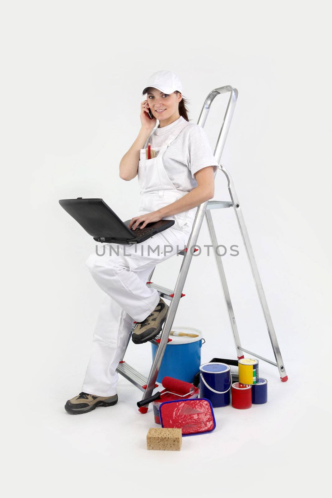 craftswoman painter working on her laptop and talking on her cell