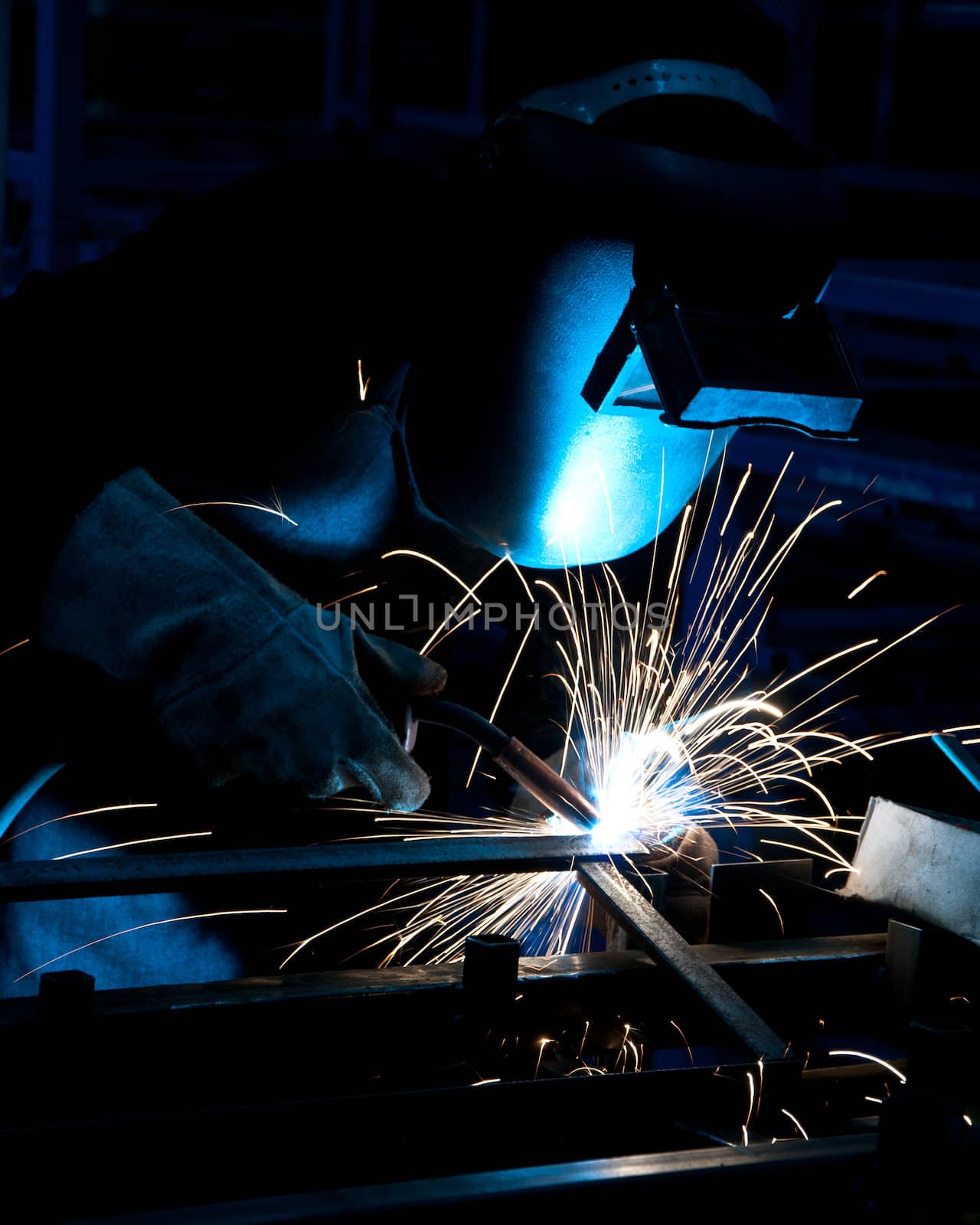 human working of welding with a lot of sparks in a metal industry factory