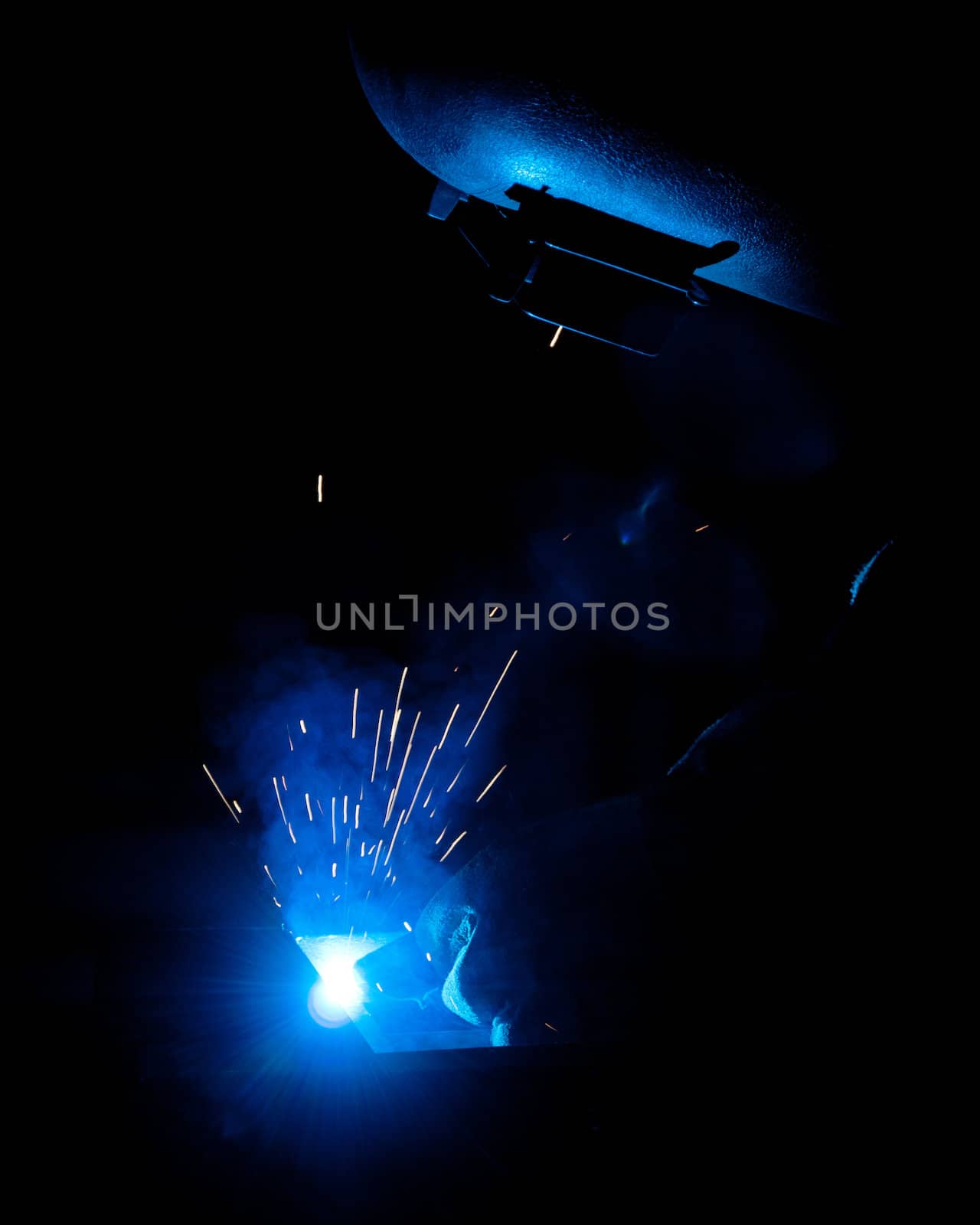 human working of welding with a lot of sparks in a metal industry factory