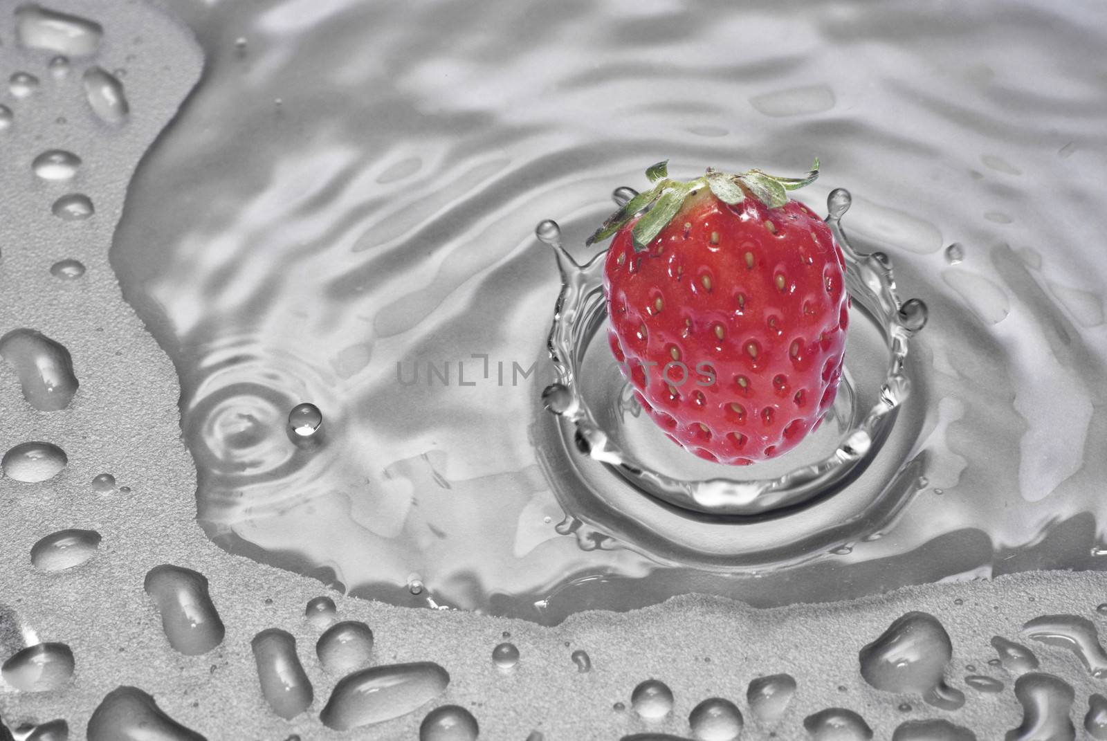 fresh strawberry falling into water