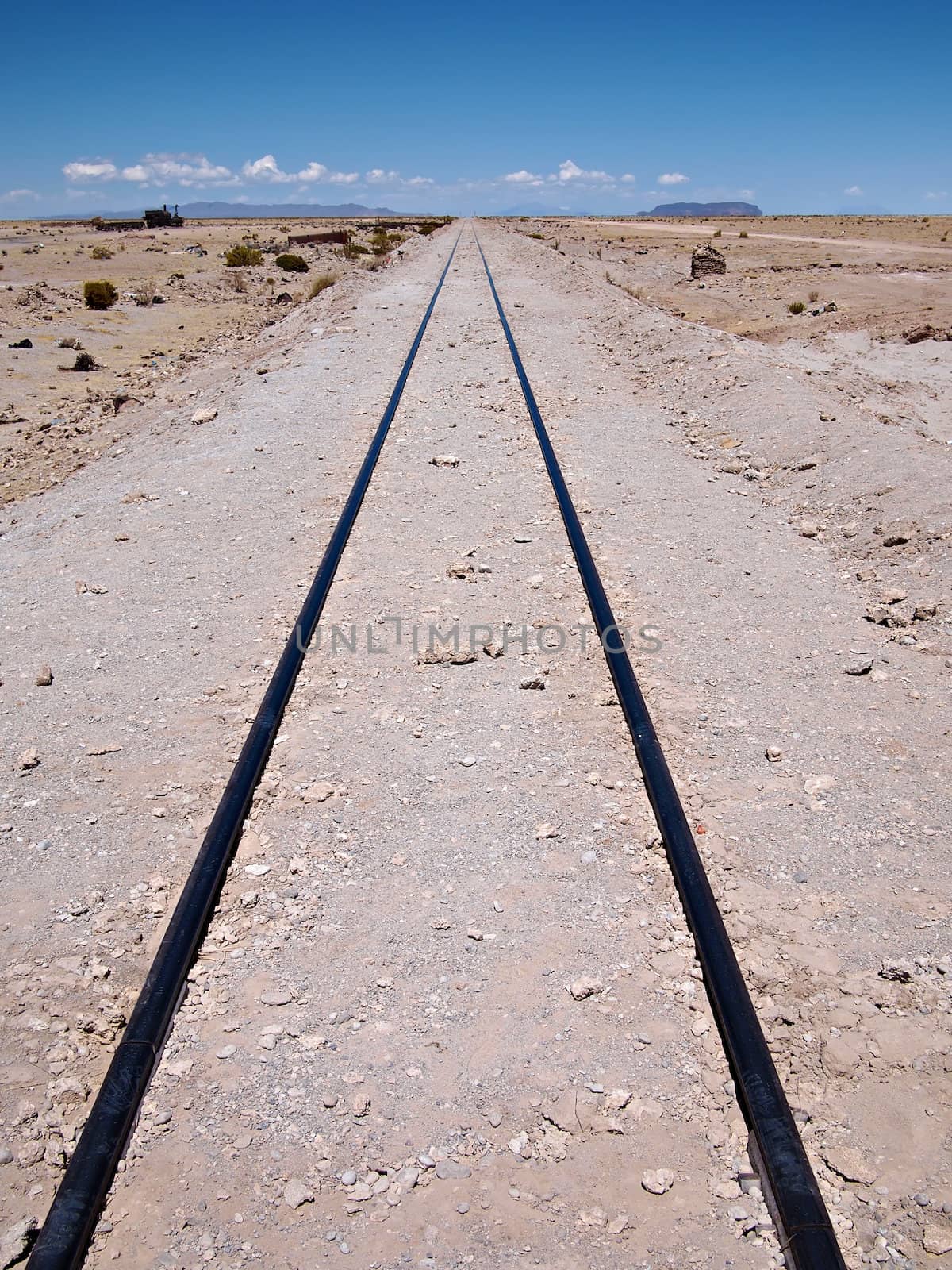 Railroad track leading far away in the distance in the desert at the train graveyard of Uyuni in Bolivia.