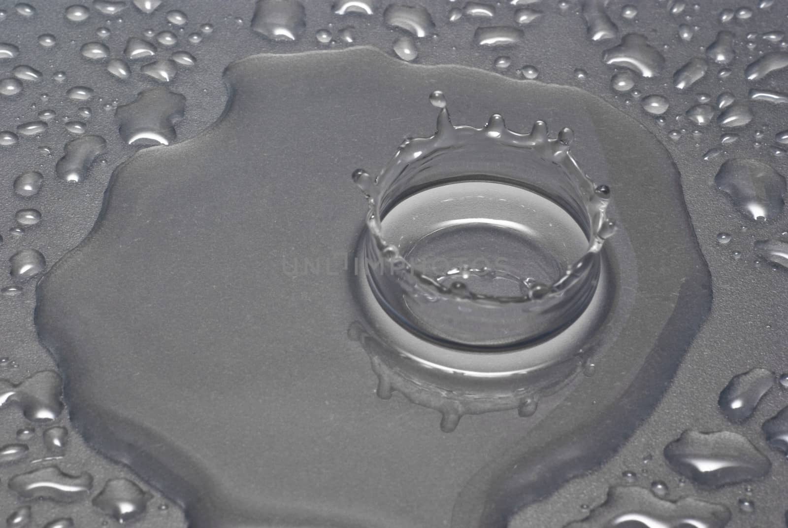 A water drop forms a crown as it splashes into a pool of water