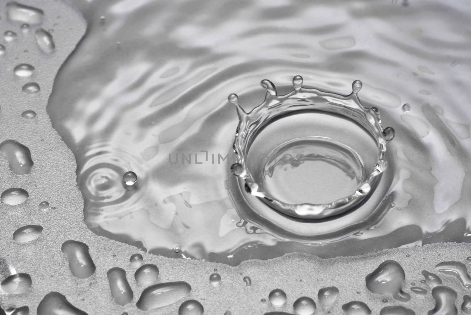 A water drop forms a crown as it splashes into a pool of water