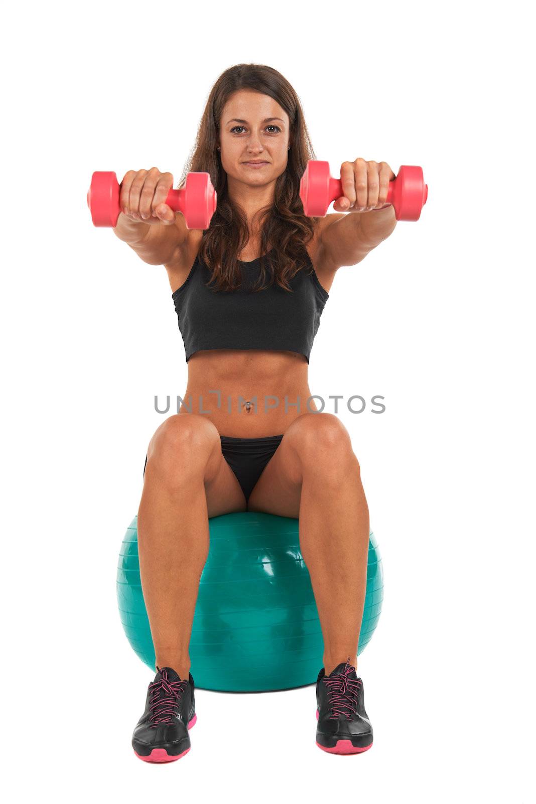 Young woman in the studio with weights and fitness ball