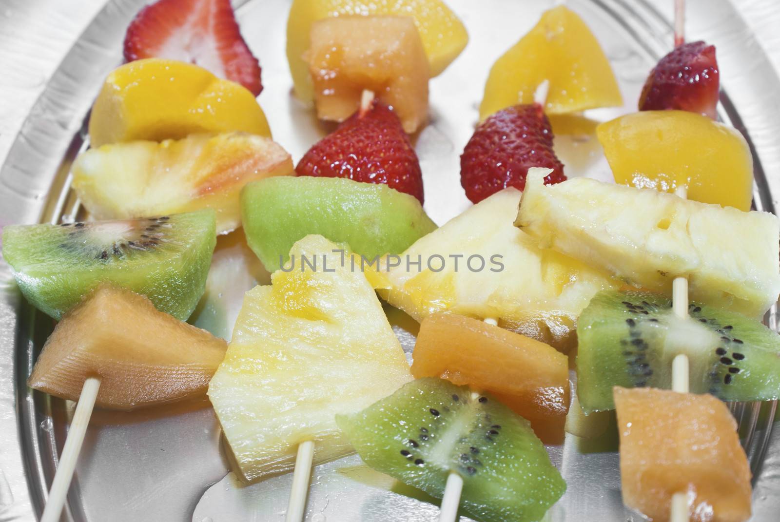 Mixed fruits on skewers close-up
