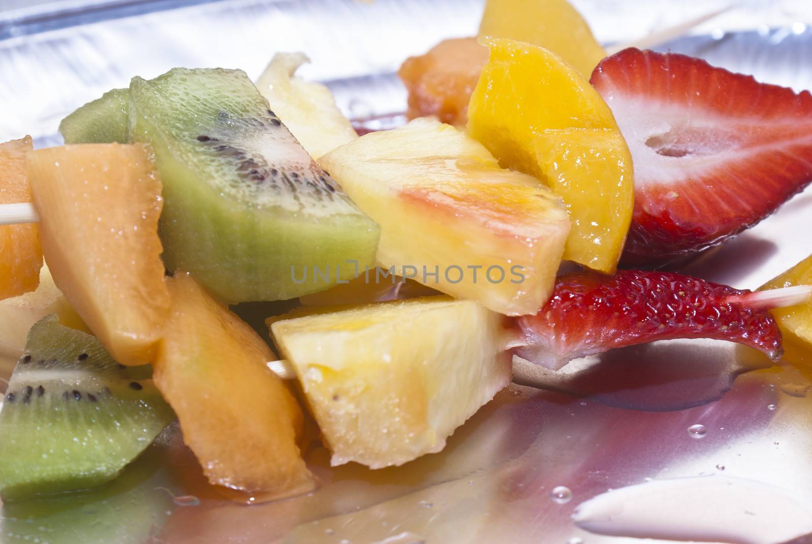 Mixed fruits on skewers close-up