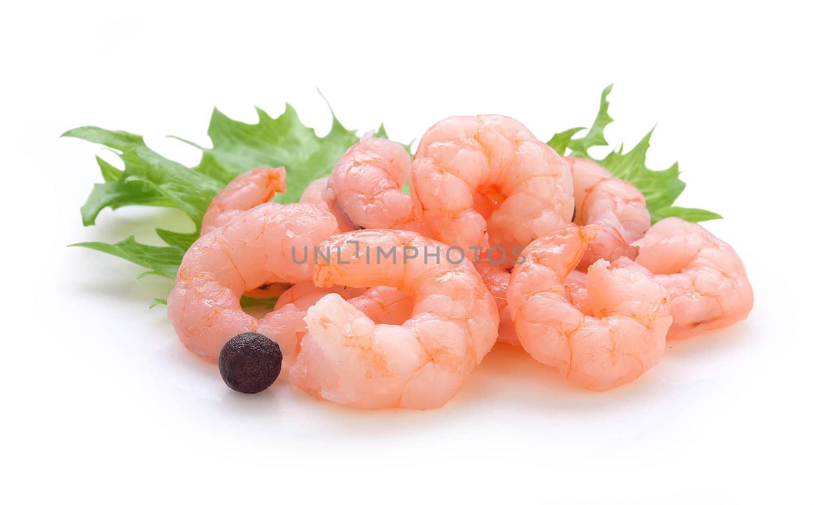 Handful of cleaned shrimp's tails with fresh lettuce and black pepper