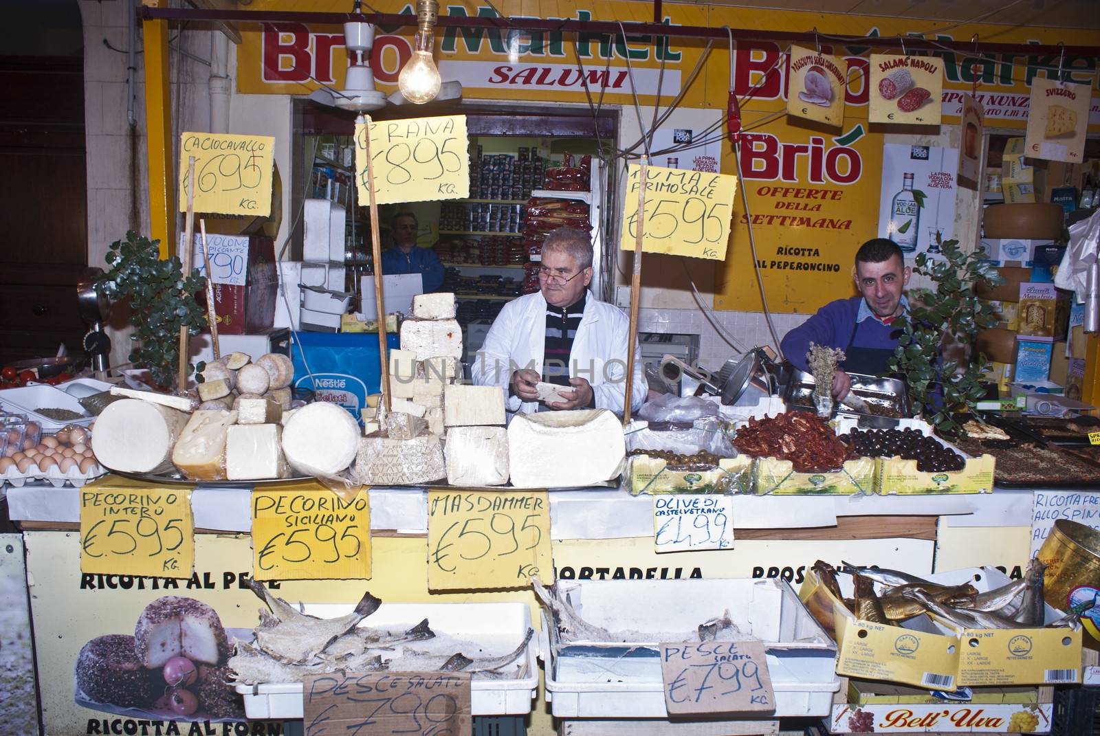 PALERMO - DECEMBER 22: men selling cheese on the local market in Palermo, called Ballaro. This market is also tourist attraction in Palermo, Sicily, Italy on Dec. 22, 2012.