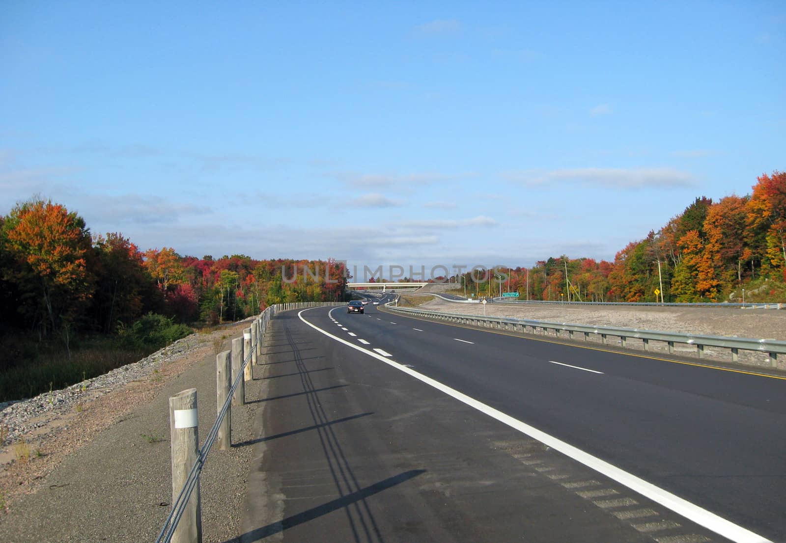 Highway in fall time under blue sky